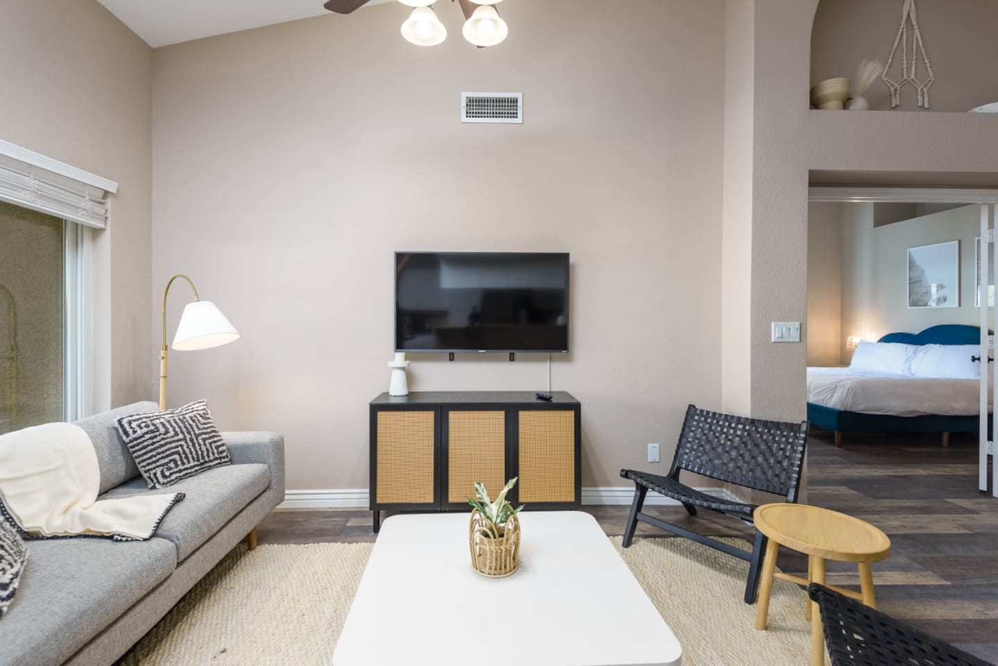 Sitting area with wall-mounted TV, comfortable seating, ceiling fan, and patio door access for relaxed downtime.