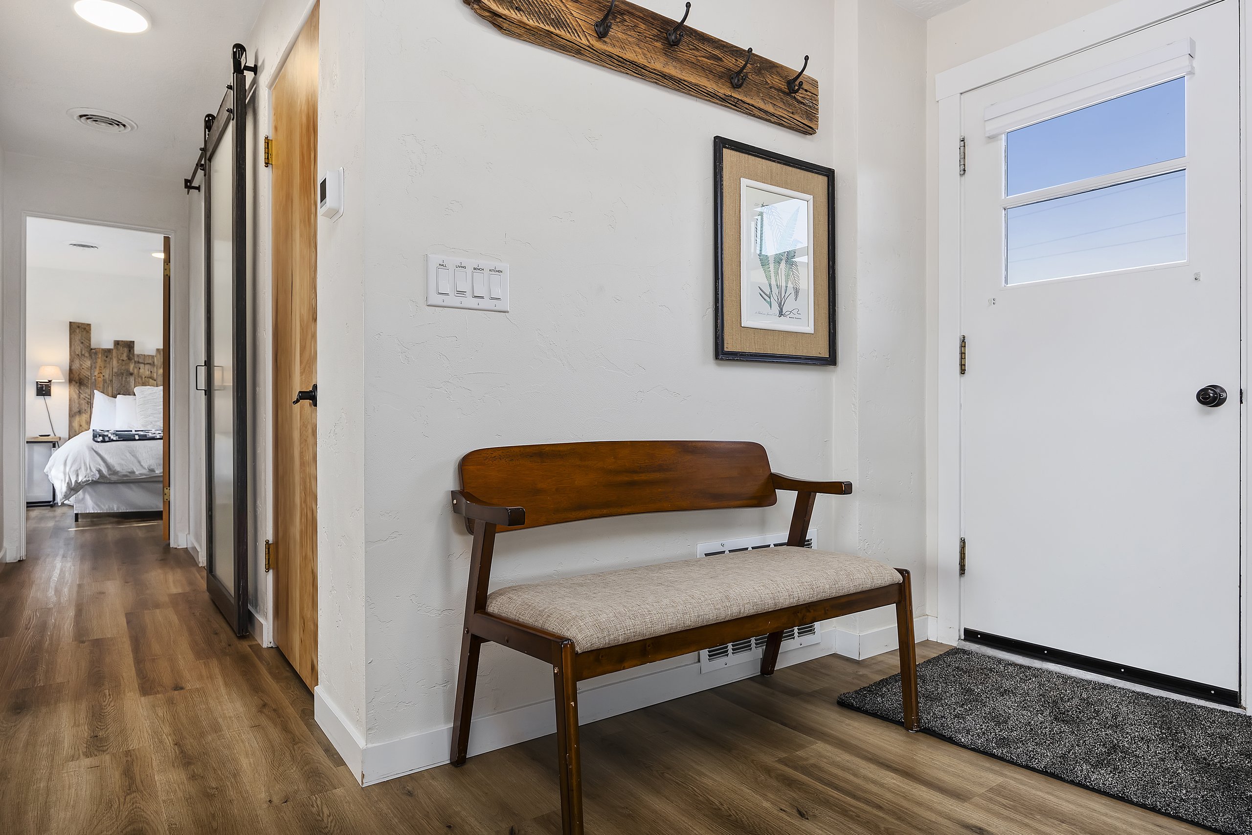 Entry bench by the patio door, with the hallway leading to the bedrooms and bath