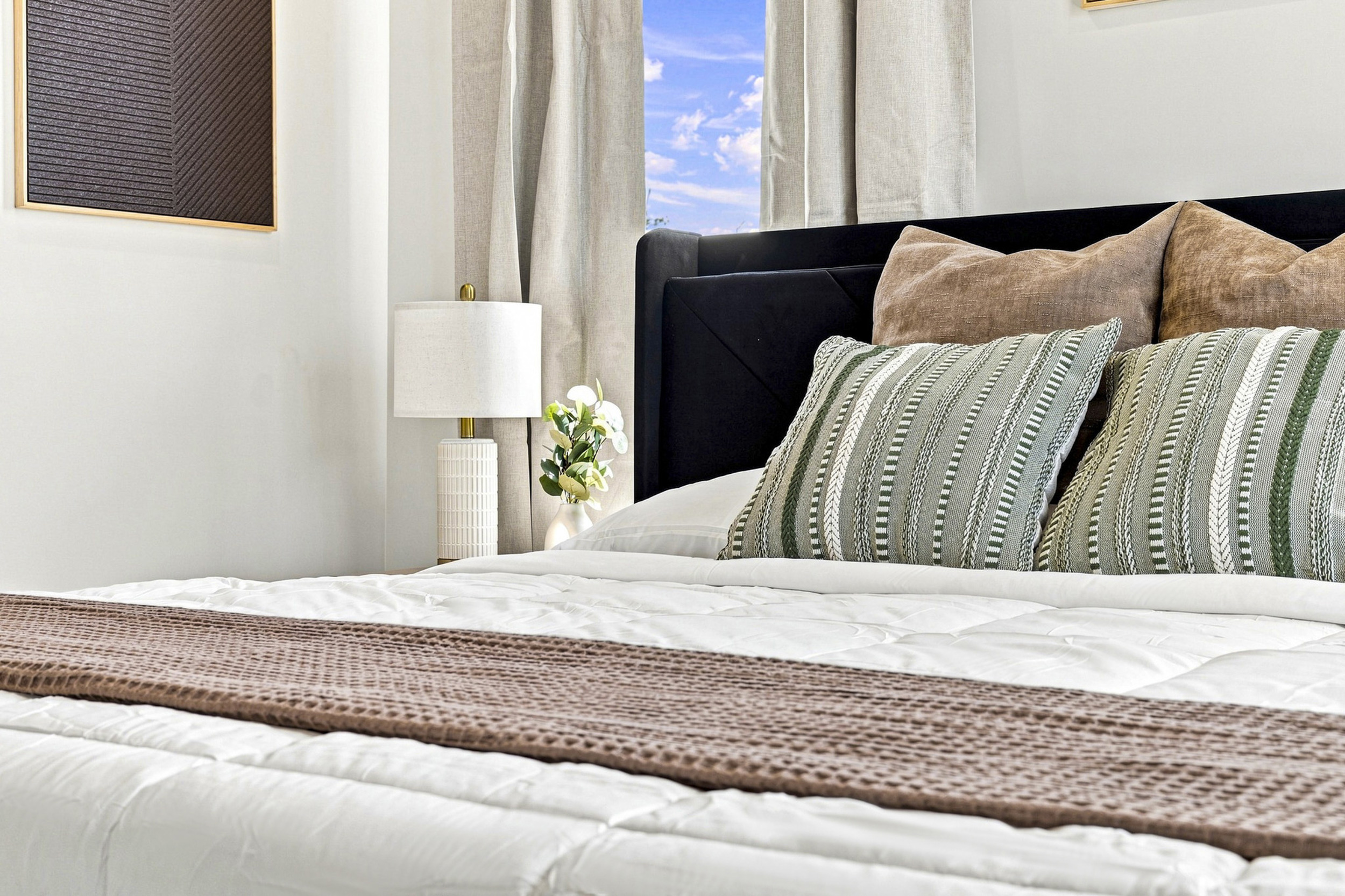 Indulge in plush bedding and vibrant pillows with stunning city views!

