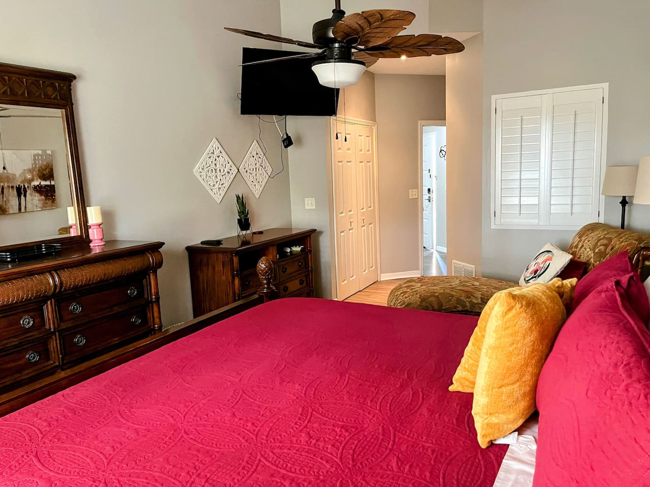 Comfortable bedroom with a large bed, dresser storage, closet access, and a relaxing layout.