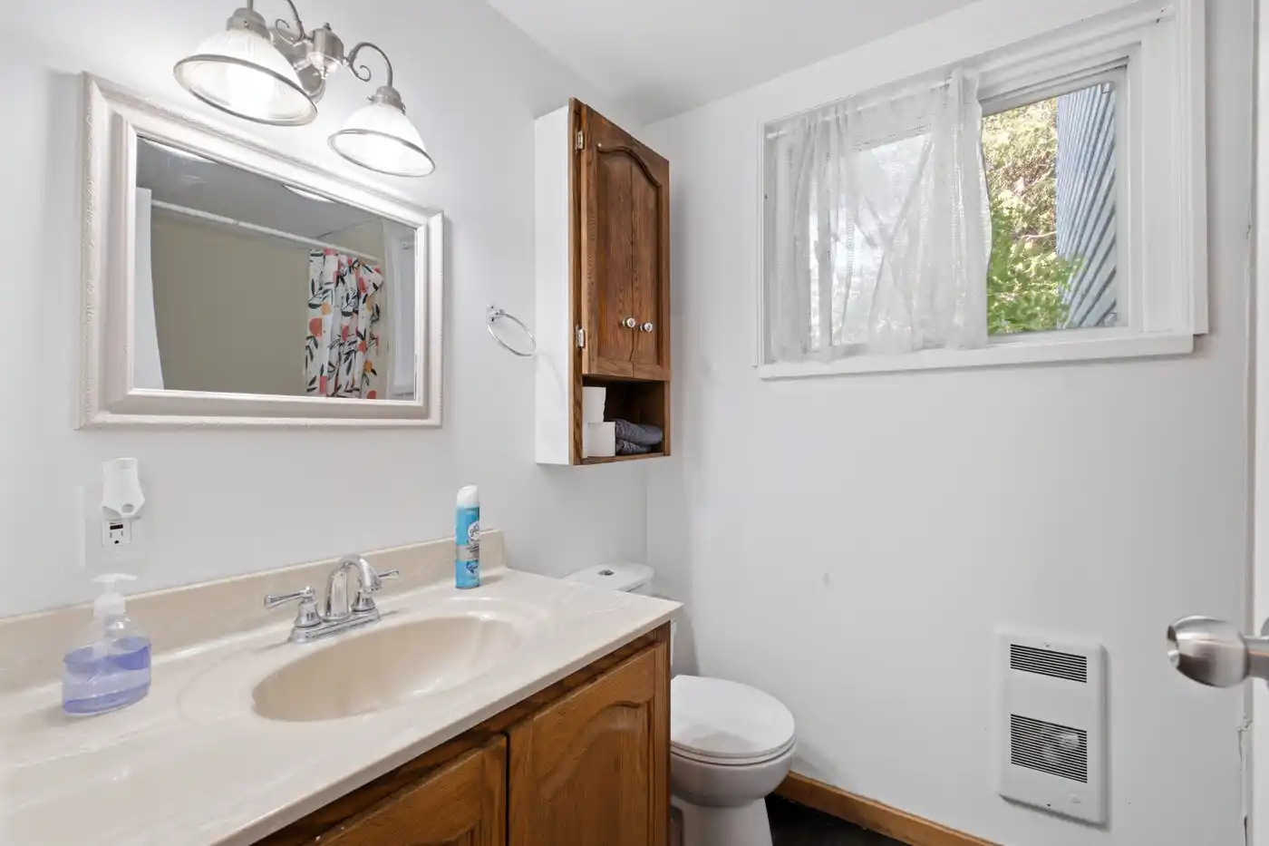 Bright bathroom with vanity, toilet and natural light
