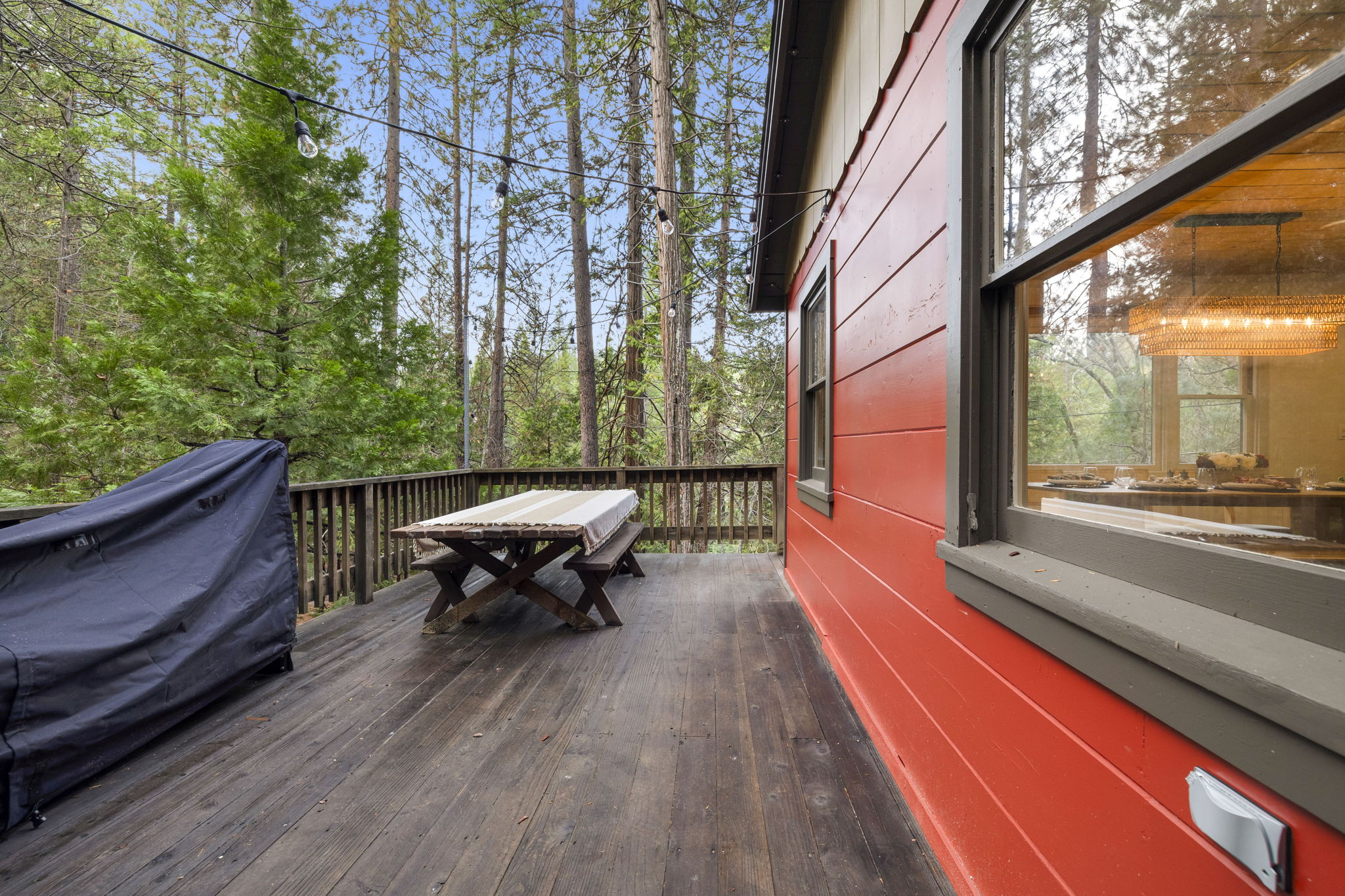 Large front deck with picnic table, cafe lights and firewood. The home also has fun LED lights in the eves for an extra vibe at night. 