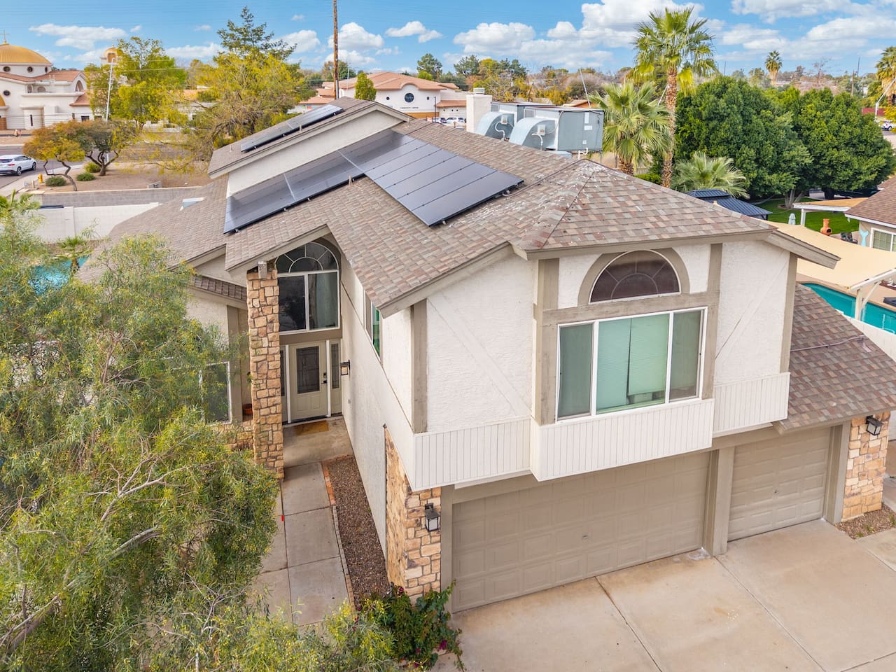 Sun-soaked from every angle, with lush landscaping framing the entrance.