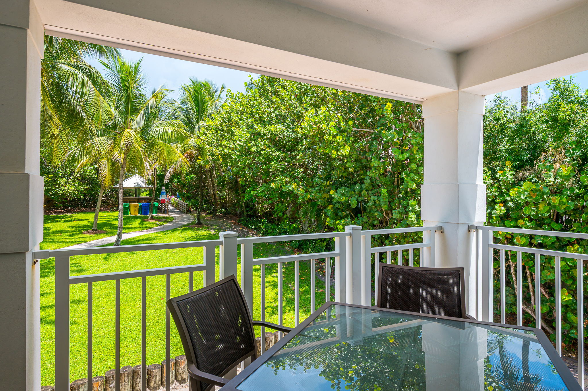 Private balcony surrounded by lush greenery, featuring outdoor dining and seating—perfect for morning coffee, al fresco meals, or evening relaxation.