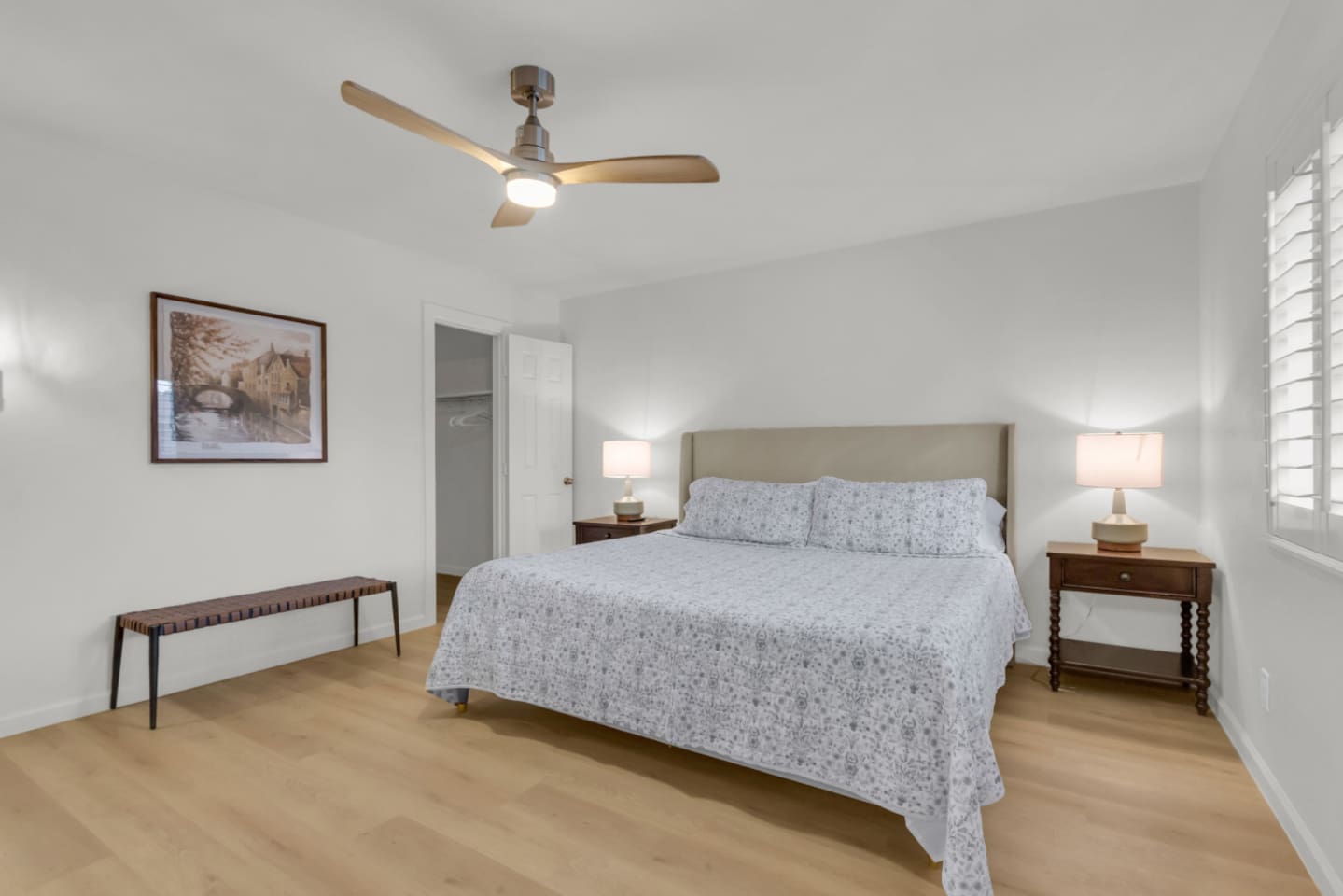 Large, airy primary suite with king bed, nightstands, and an inviting layout. Stay comfortable with central air conditioning and room-darkening shutters.