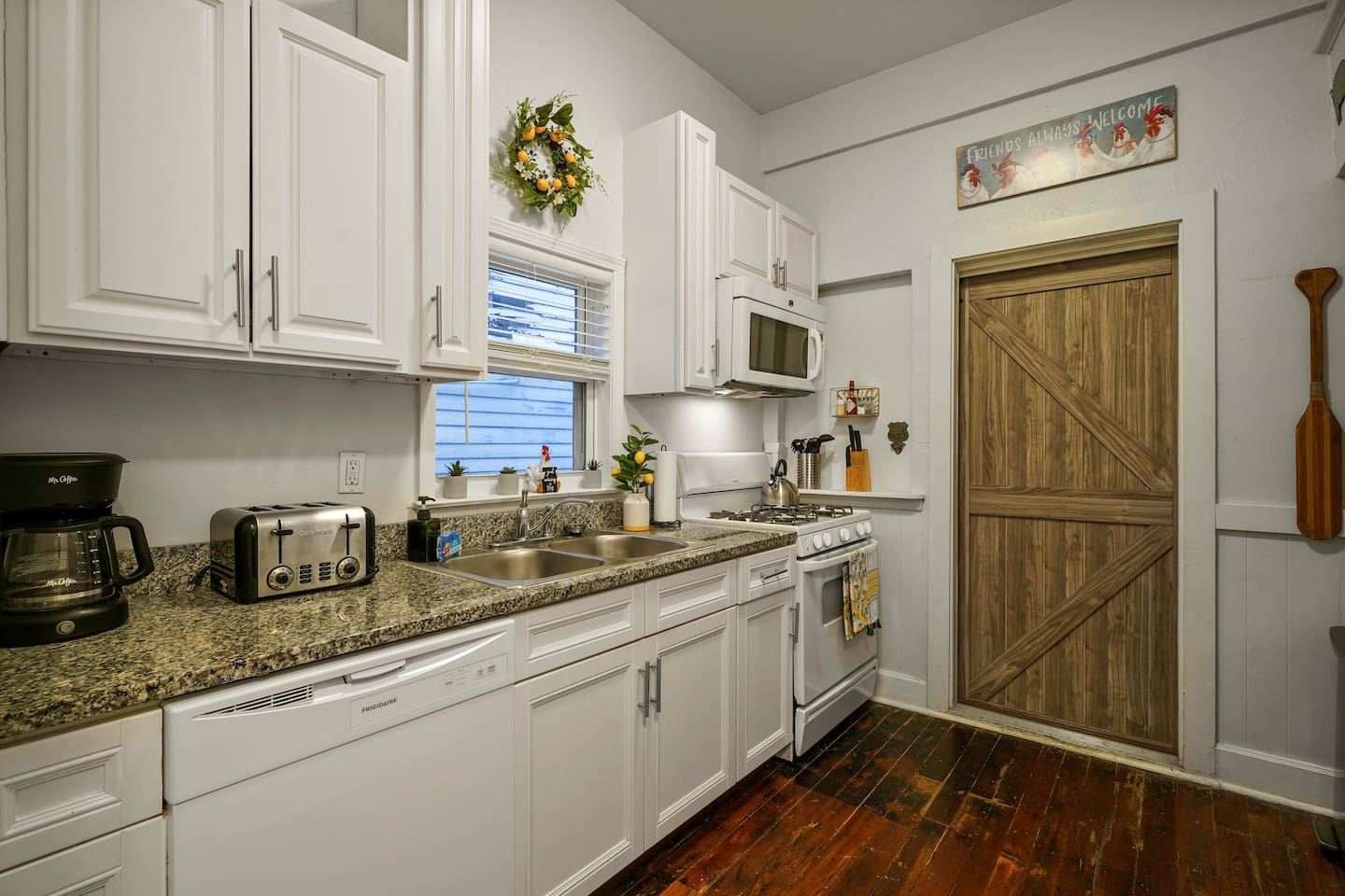 Fully equipped farmhouse kitchen with coffee, sugar, creamer, water filter, wine glasses, pots, pans, and everything you need to whip up a meal.