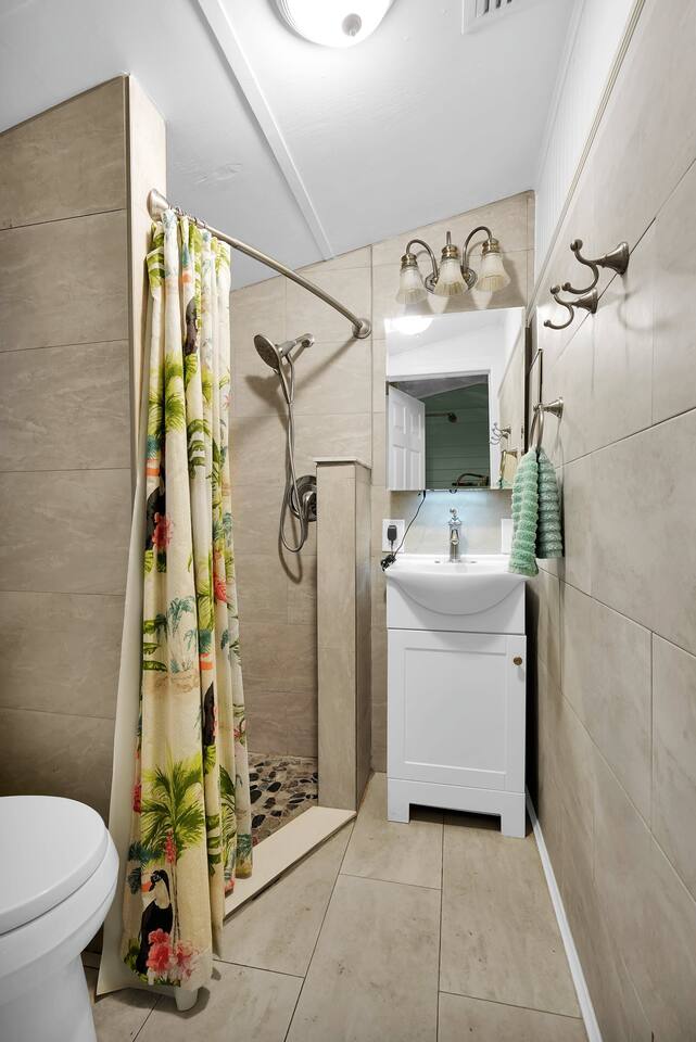 Shared bathroom next to the kitchen with full shower and sink