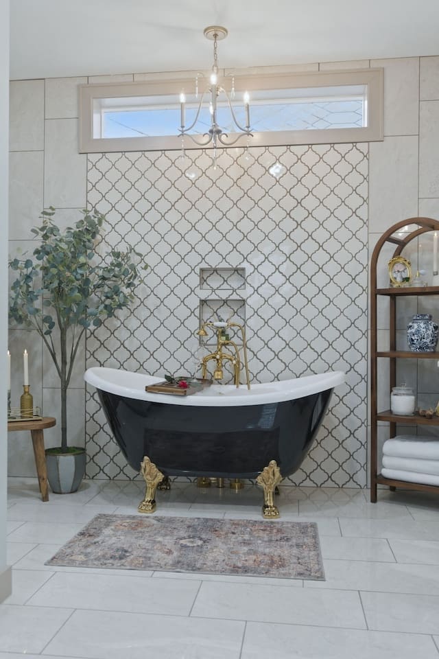 Elegant freestanding tub beneath a statement chandelier, creating a bright and luxurious spa-like ambiance
