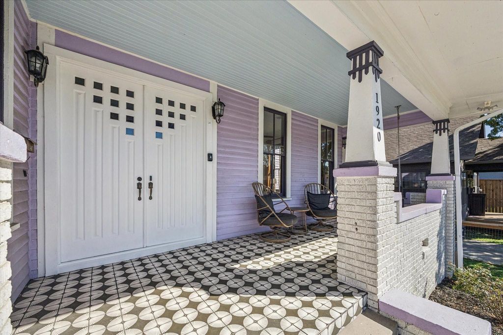 A welcoming covered front porch sets an edgy tone with eclectic tile flooring, classic columns, and charming architectural details that highlight this home’s historic character and bold curb appeal.