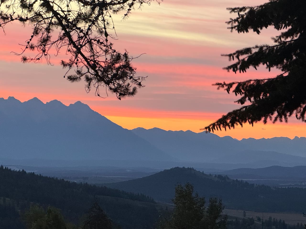 Mountain Panorama: A breathtaking east-facing view from the private deck overlooking the Rocky Mountain range during a golden sunrise.
