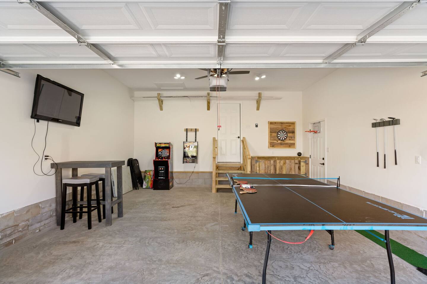 entertainment garage. featuring ping pong, putt putt, darts, tv, arcade games, basketball. Also outdoor games such as cornhole boards, chipping game, etc.