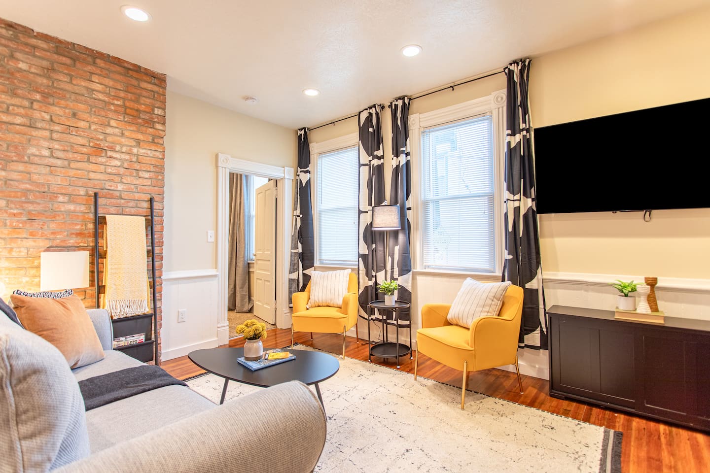 A warm and inviting living area featuring a plush sofa, soft lighting, and a dedicated workspace with a sleek desk and comfortable chair, perfect for productivity and relaxation.
