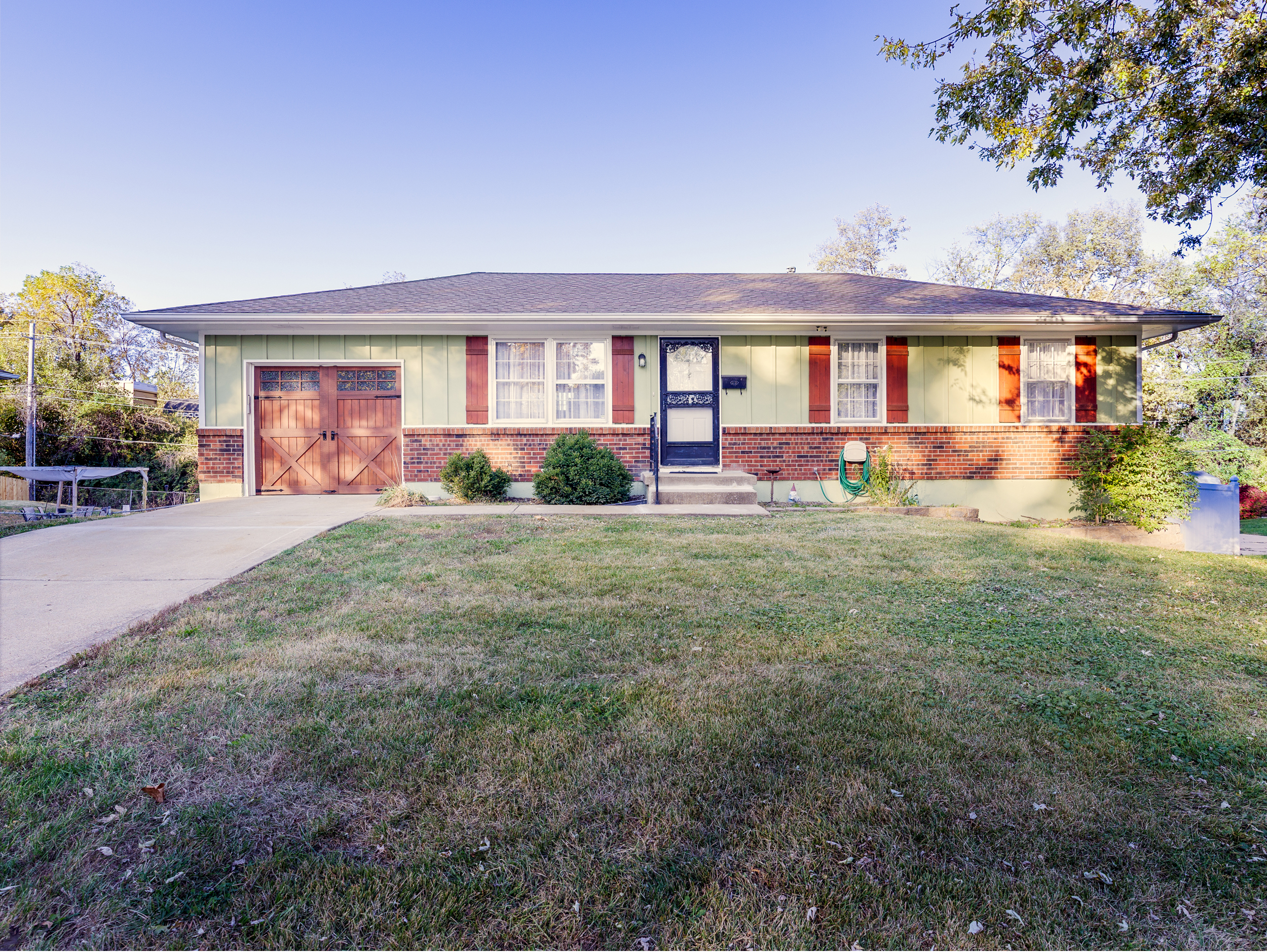 Wide exterior angle showing the home’s clean lines, front lawn, and convenient street access.