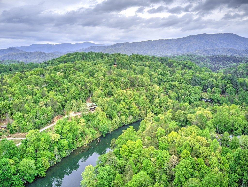 Your ultimate mountain getaway - log cabin surrounded by forest and river below