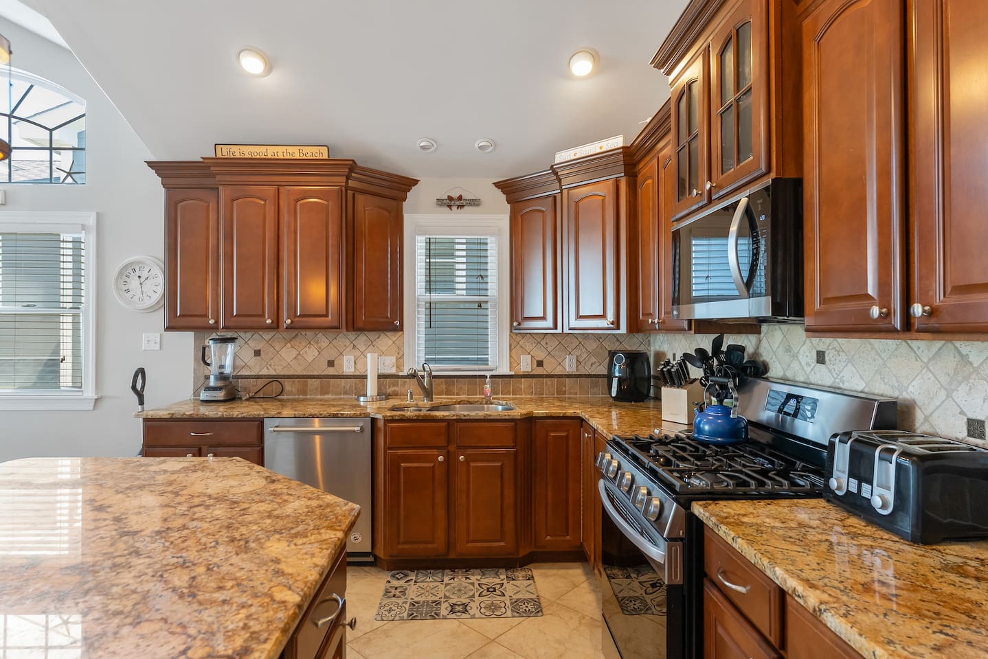 Full kitchen with stainless steel appliances, large island for additional seating, ample prep space and separate beverage refrigerator. 