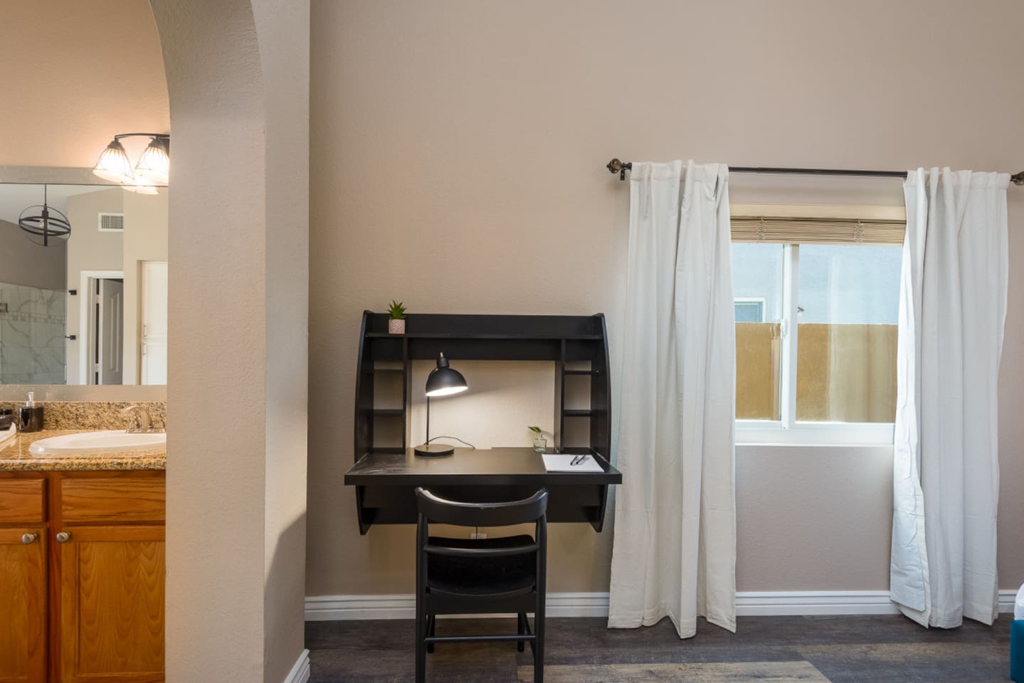 Desk area inside the primary bedroom, with task lighting and easy access to the ensuite bath.