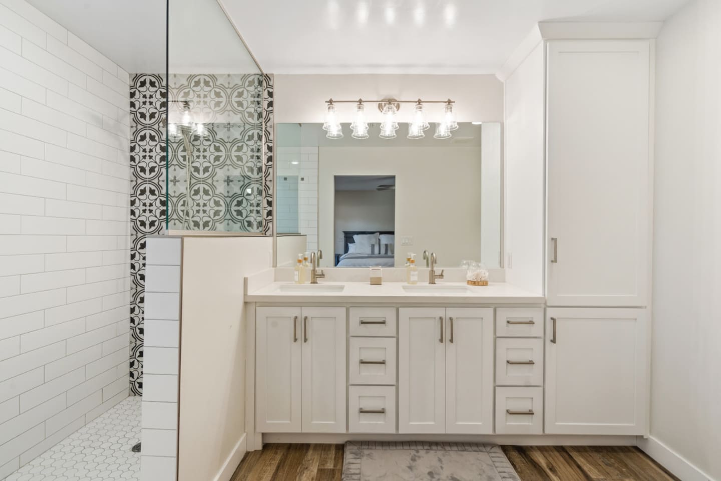 Ensuite bathroom with double sinks, tall storage cabinet, and a stylish walk-in shower.