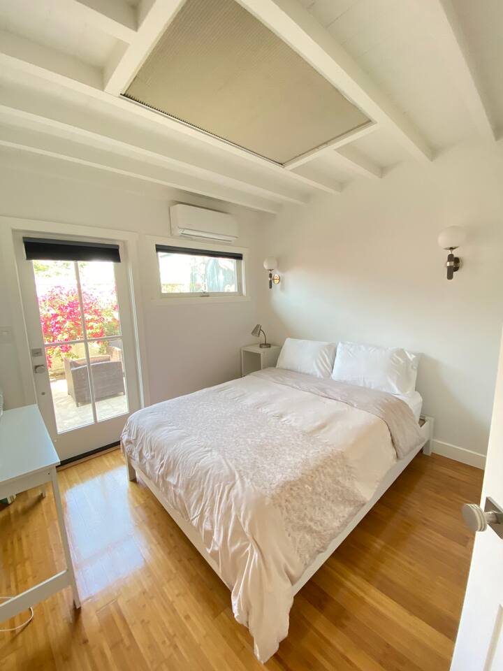 Sunny guest bedroom with peaceful garden views.