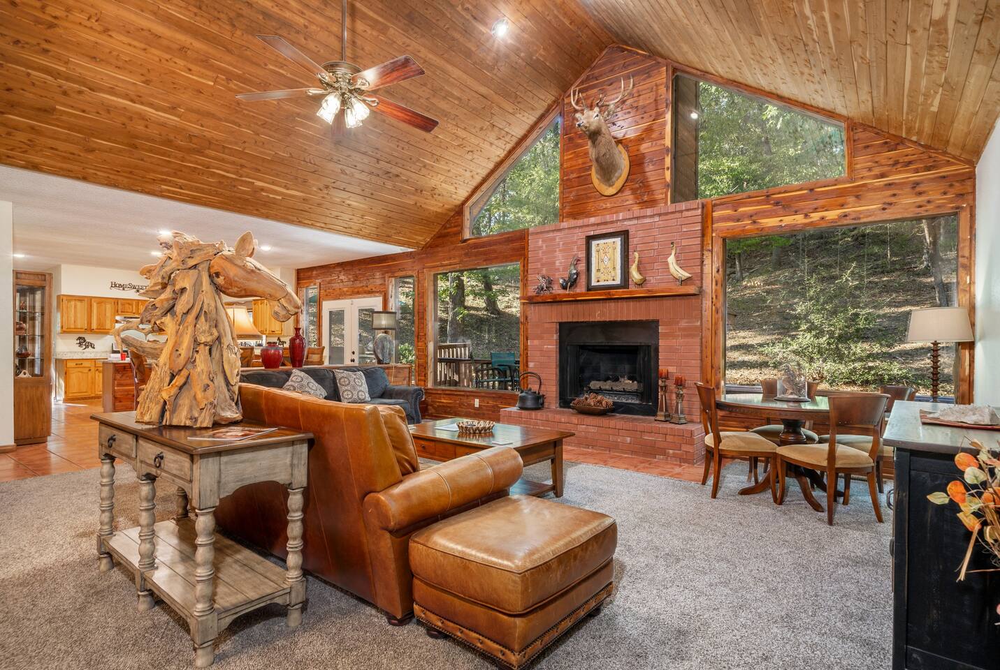 Spacious family room with vaulted ceilings, views of the woods and wildlife, gas fireplace, and plenty of room for everyone. There is a smart tv, a card/ puzzle table, leather sofas and loads of ambiance.