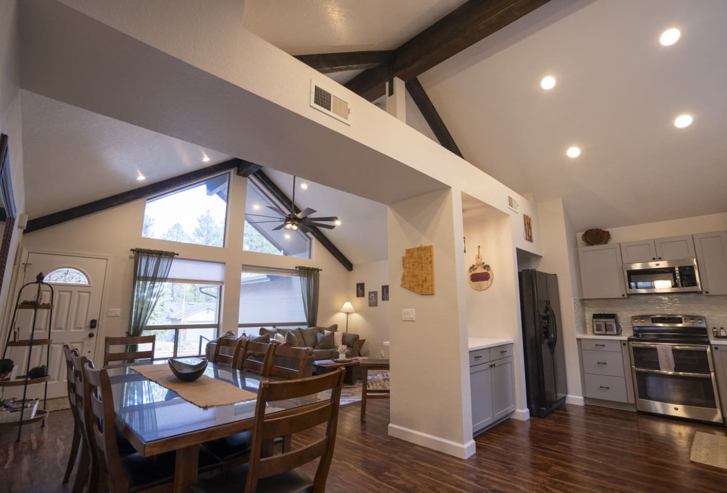 Dining and living area with high ceilings, wood floors, and a comfortable layout for gathering.