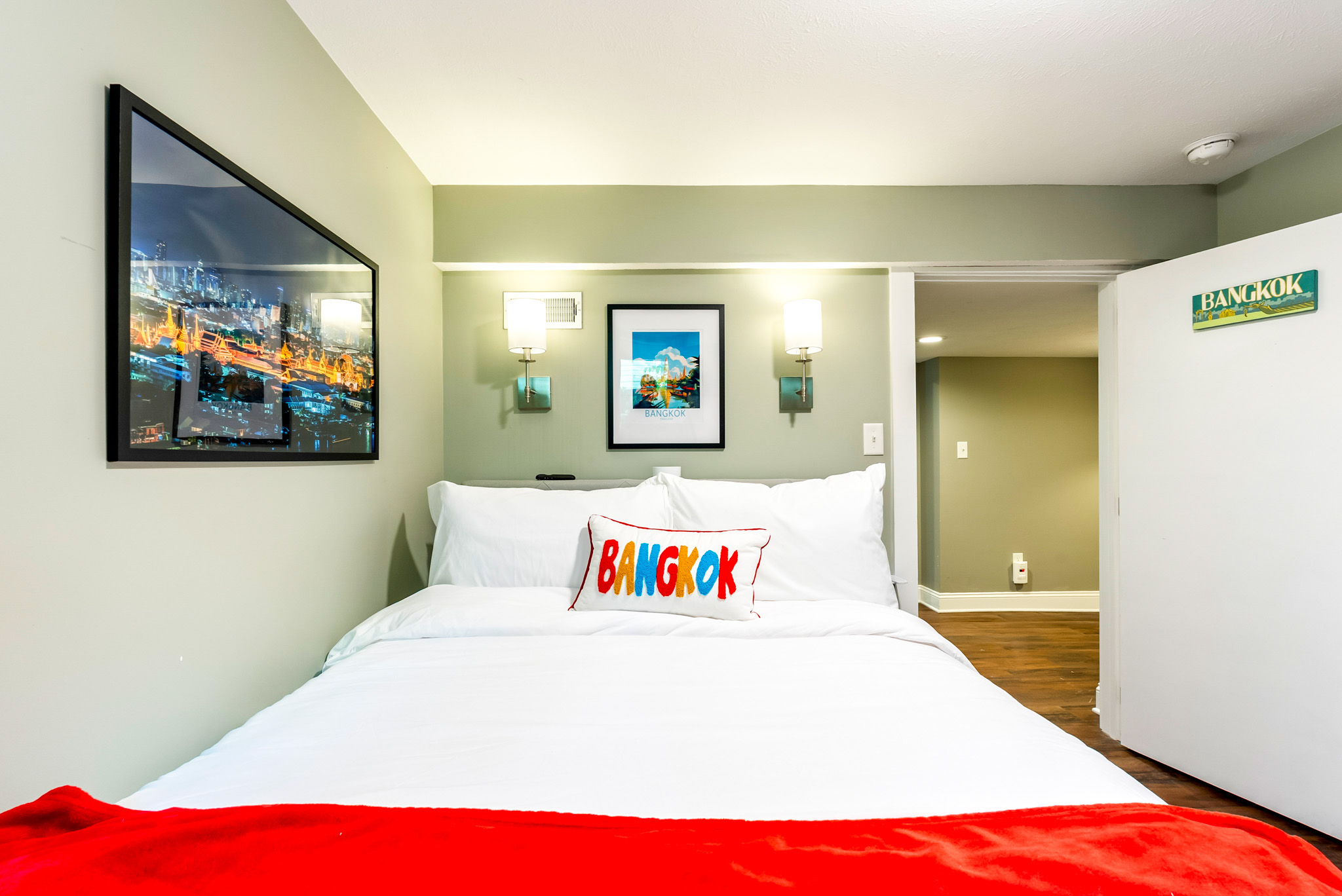 Retreat to the cozy Bangkok Room, featuring a comfortable full-size bed, warm transitional lighting, and premium linens designed for total relaxation.