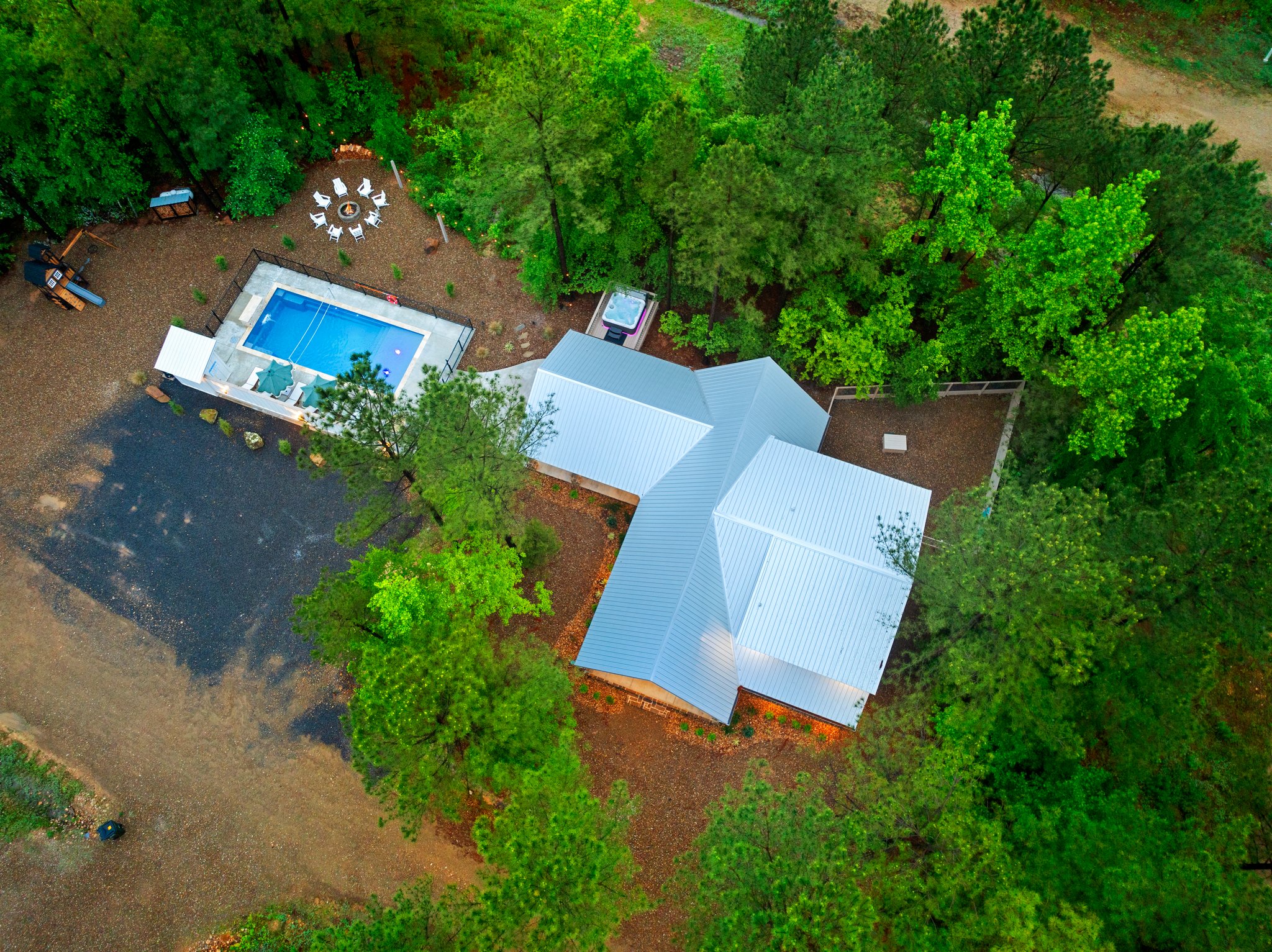 From above, the layout comes to life. Pool days, firepit nights, hot tub moments, patio hangs, playset fun, a fenced yard for pups, and convenient parking just steps away.