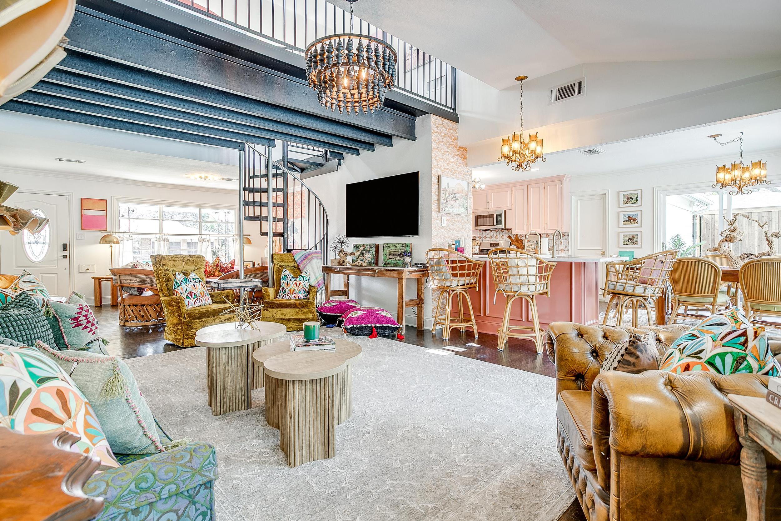 Spiral staircase, dual chandeliers, leather sofa, pink kitchen. The main living area at Texas Two-Step was built for groups who expect more.