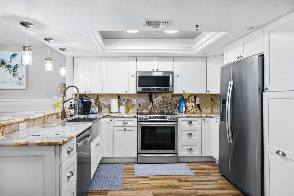 Spacious fully stocked kitchen with stainless steel appliances and storage ideal for preparing meals during your beachfront stay.