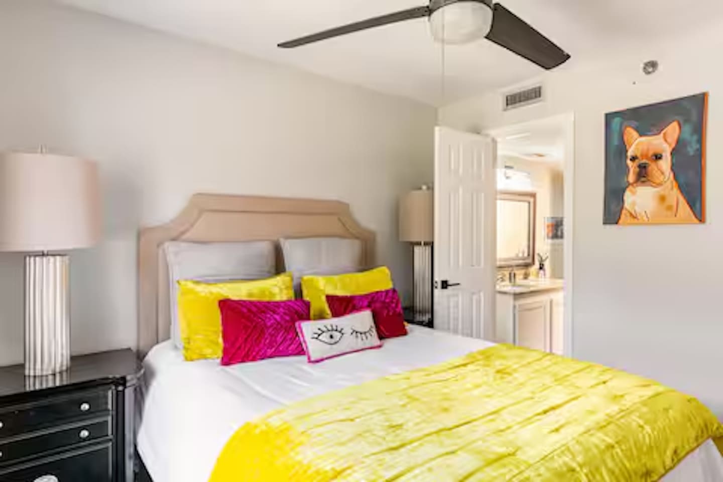 Bedroom with queen bed and colorful accent pillows.