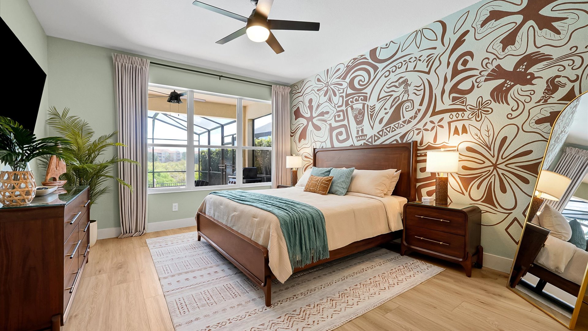 Moana King Suite: Main-floor king bedroom with a hand-painted Polynesian mural, TV and peaceful conservation views.