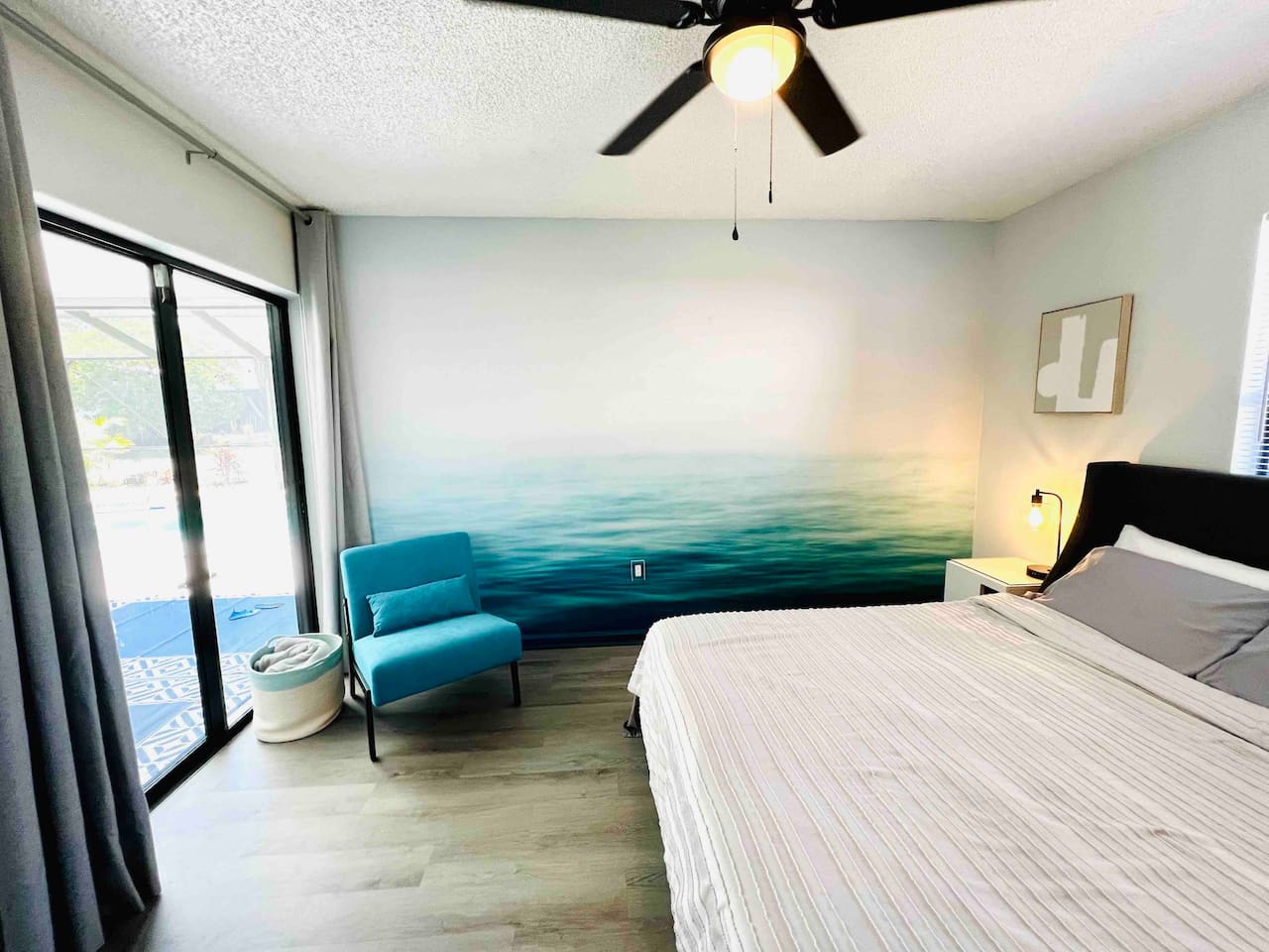 2nd bedroom with queen size bed and glass sliding door overlooking the pool area. #instagramWorthy  #uniquestay #springhillairbnb #stylishstay
