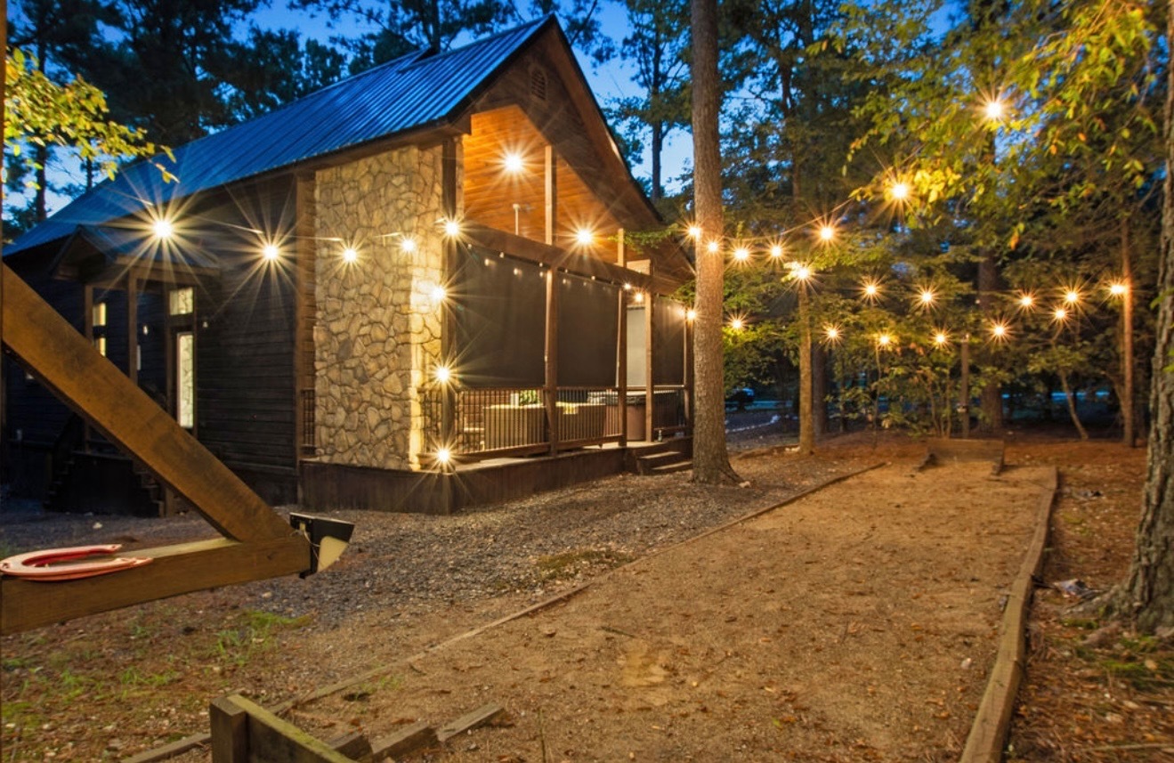 Relax under the glow of string lights surrounded by towering pines—the perfect setting for magical nights outdoors.
