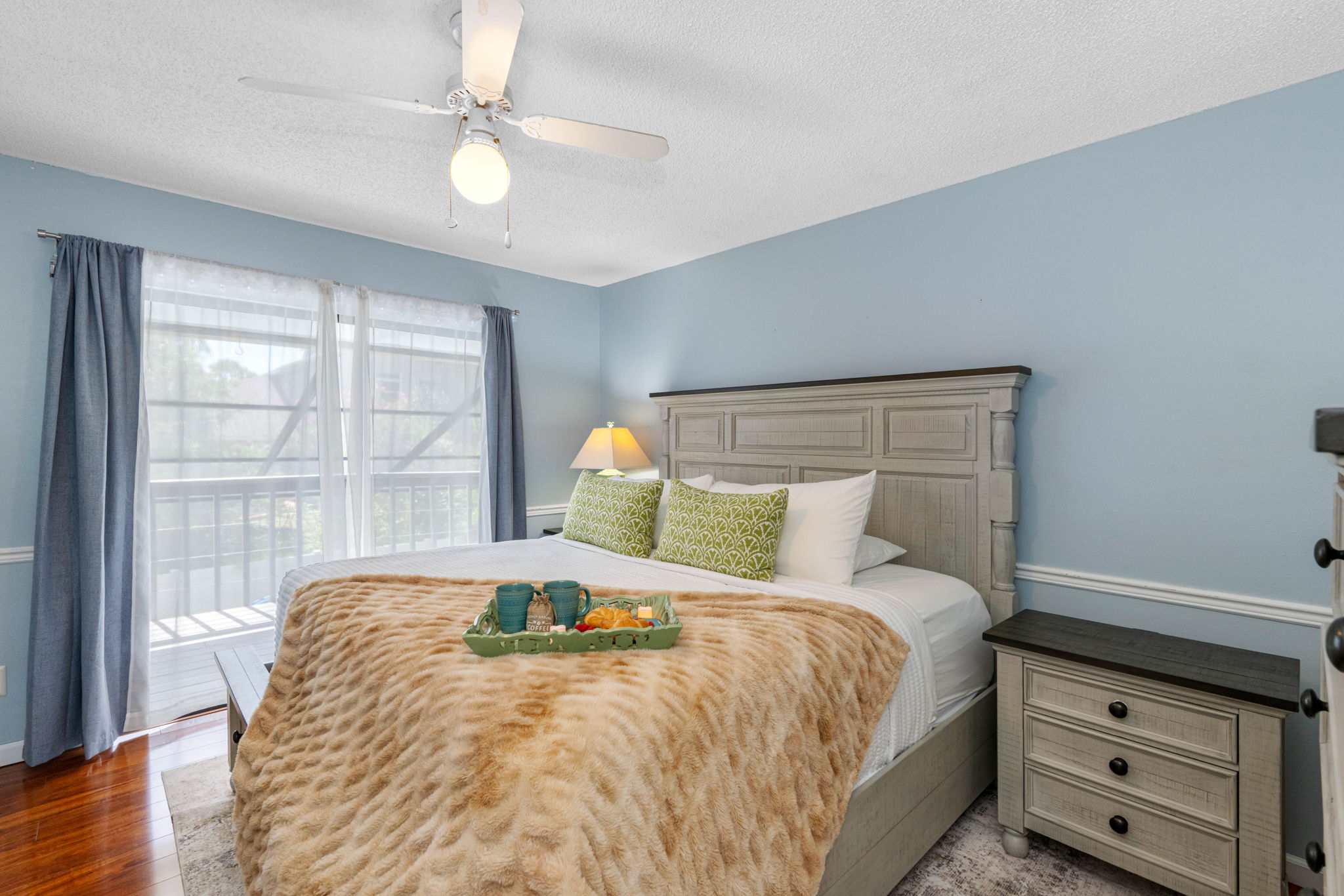 This inviting bedroom features soft blue walls, a comfortable king-size bed, and a calming atmosphere—perfect for a restful night's sleep.
