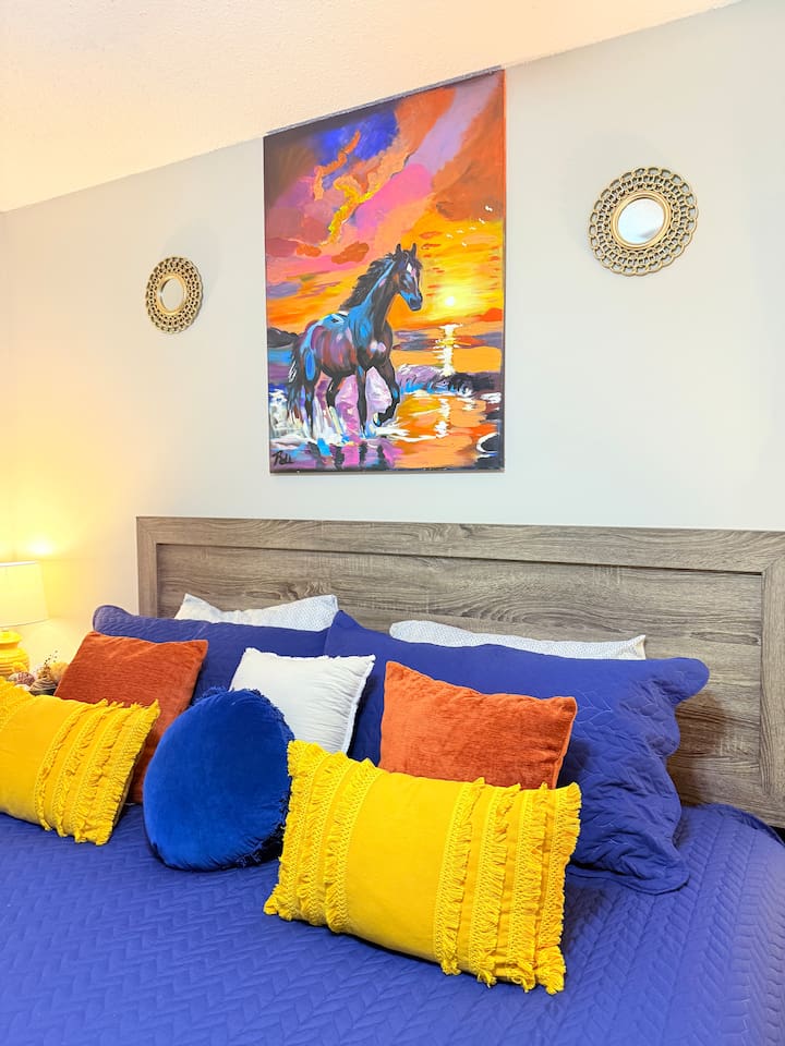 A mix of bold pillows and soft bedding makes this bedroom as fun as it is comfortable. 