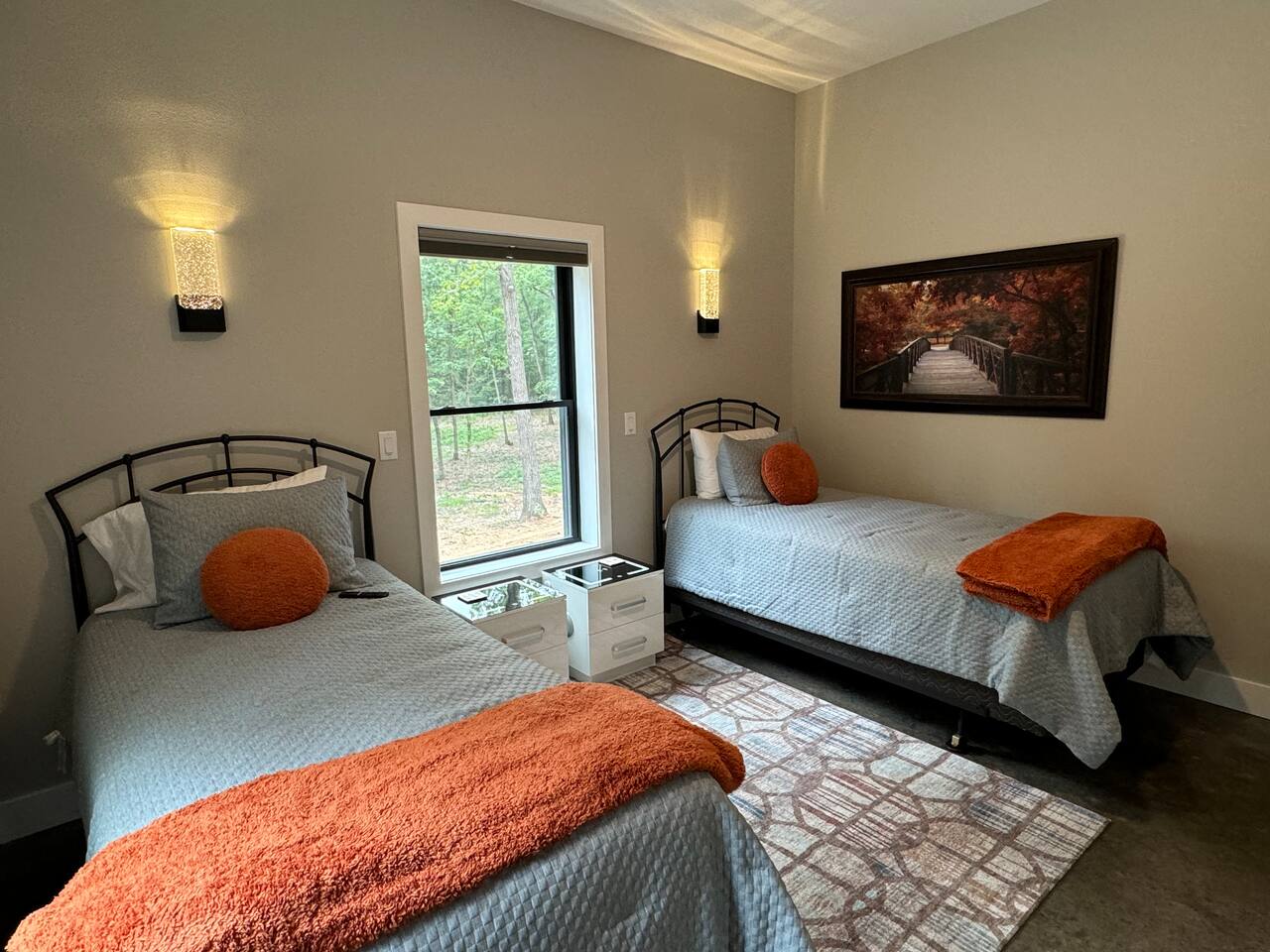 Bedroom number two has two XL twin beds with nightstands, chair, rug, and plenty of natural light.