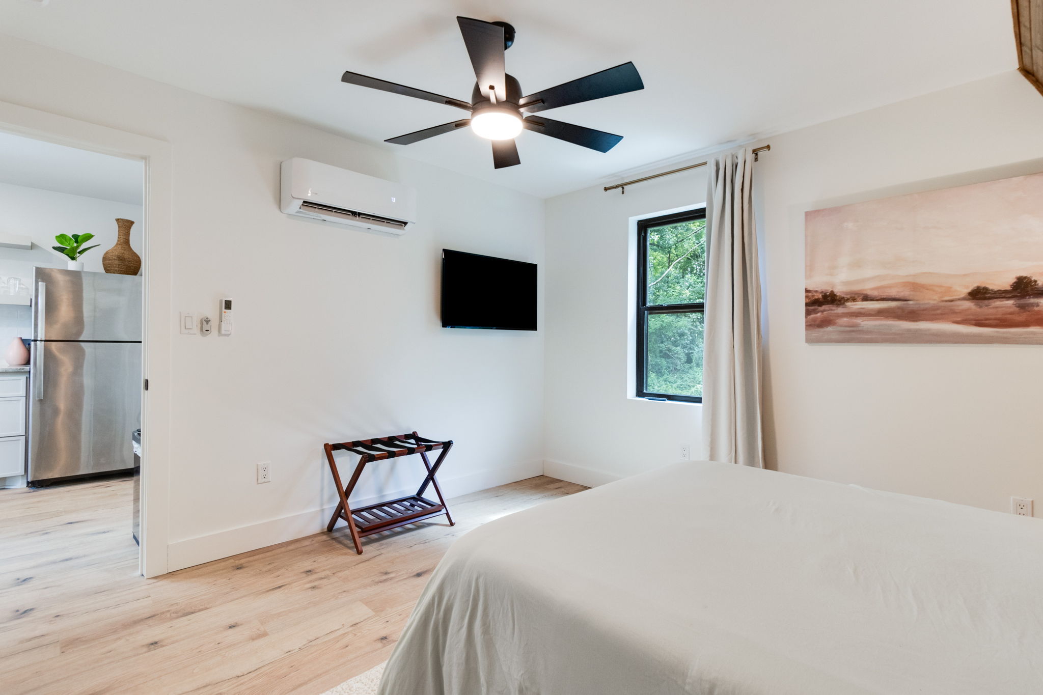 Downstairs bedroom with smart TV and AC