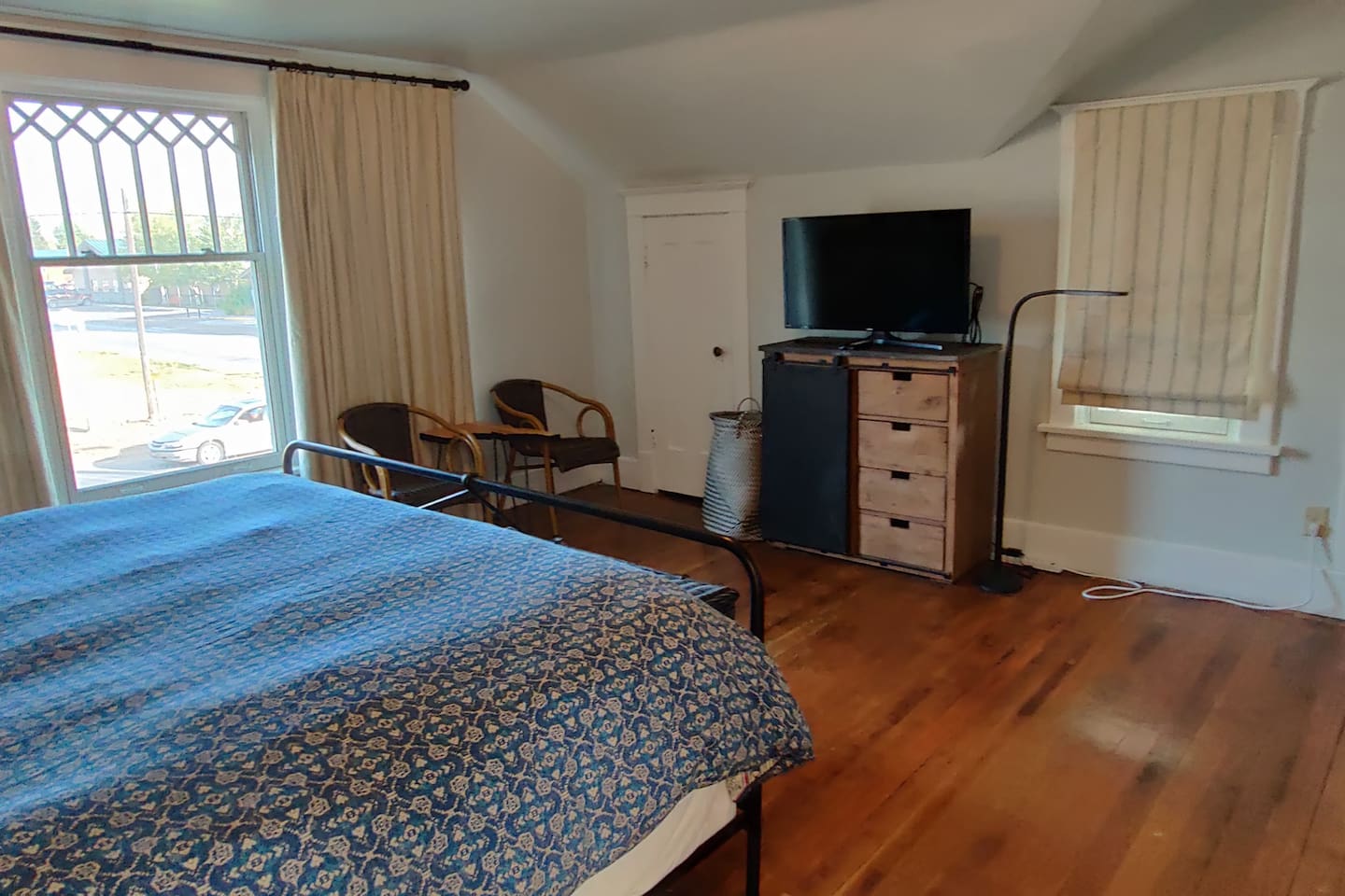 Large second-floor bedroom with TV and access to balcony.