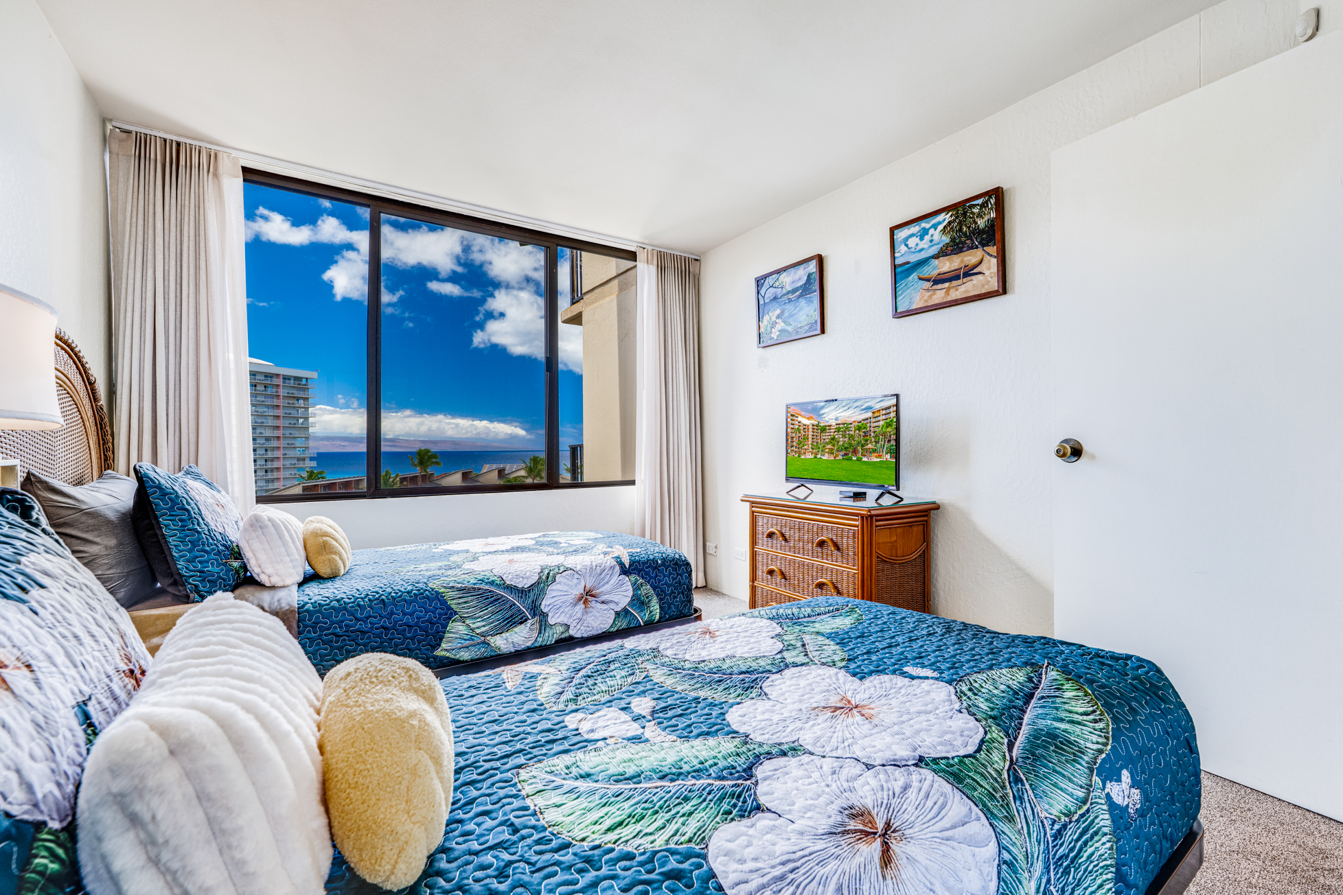Bright bedroom with two twin beds and a stunning ocean view.