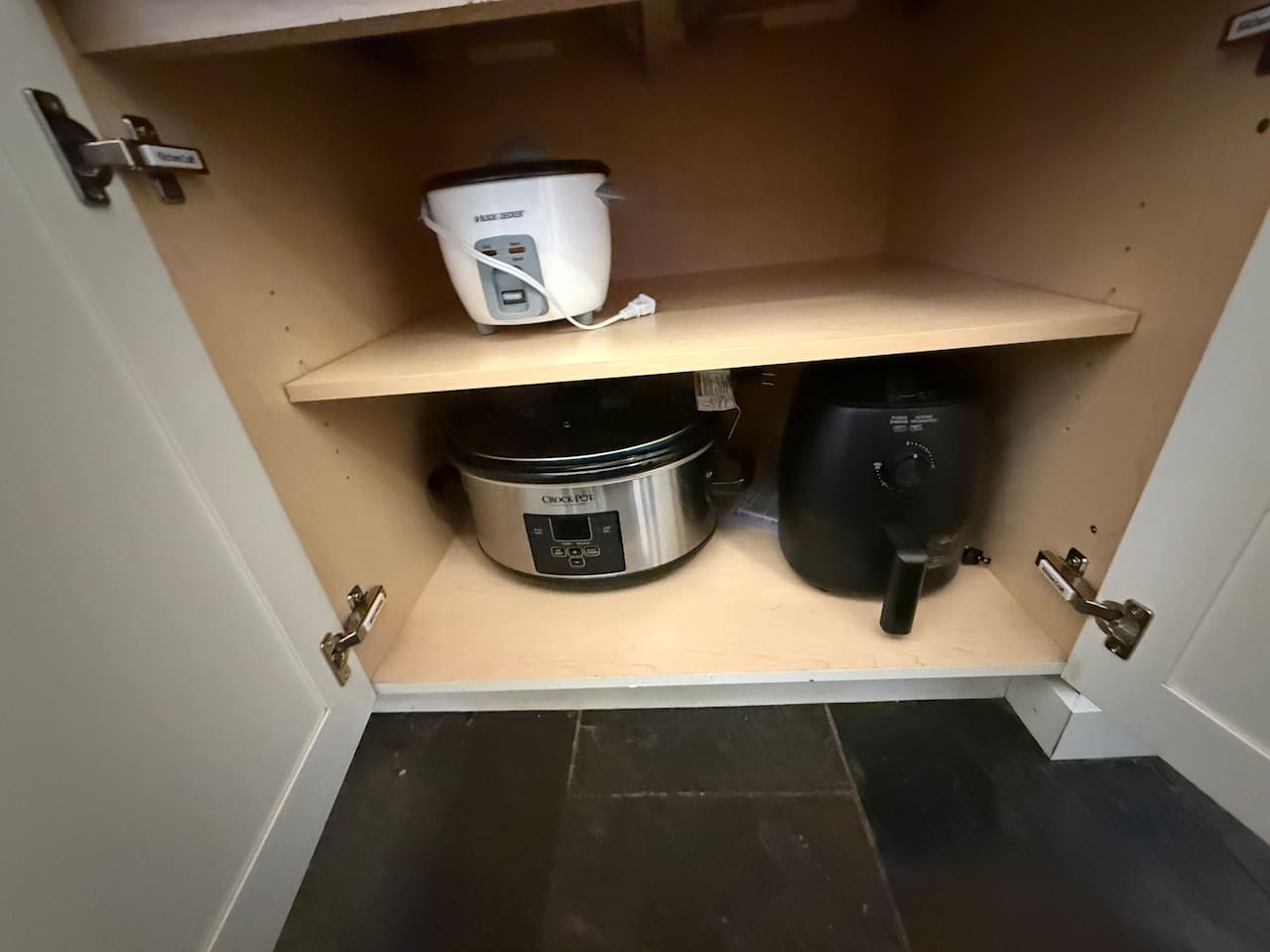 Small Appliance Nook: Convenient cabinet storage houses essential small appliances including a slow cooker, rice cooker and air fryer.  