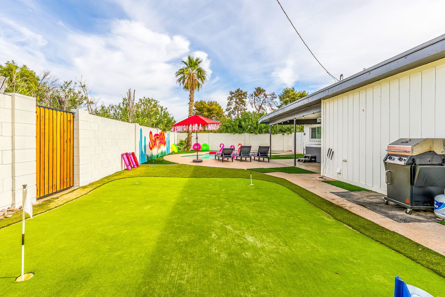 This vibrant backyard features putting greens, a fun Scottsdale mural, and all the essentials for relaxing or playing in style.