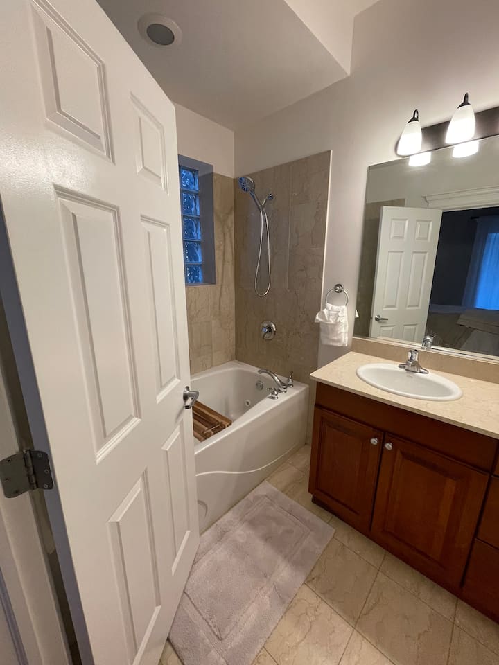 Clean bathroom with shower and fresh towels provided.