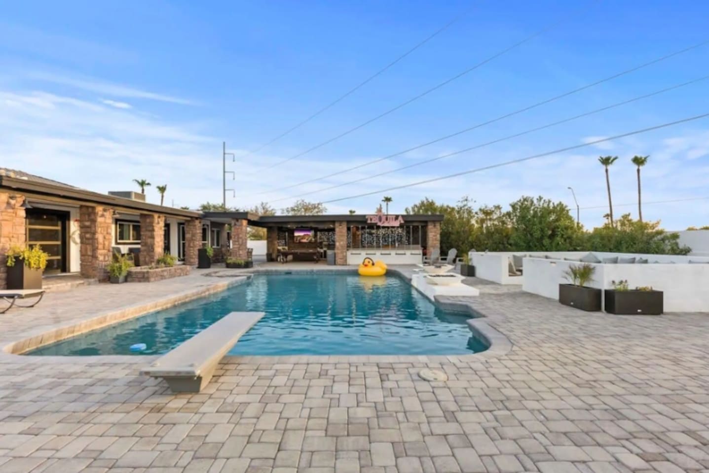 A diving board pool stretches toward the palm-lined "Tequila" bar and covered lounge.
