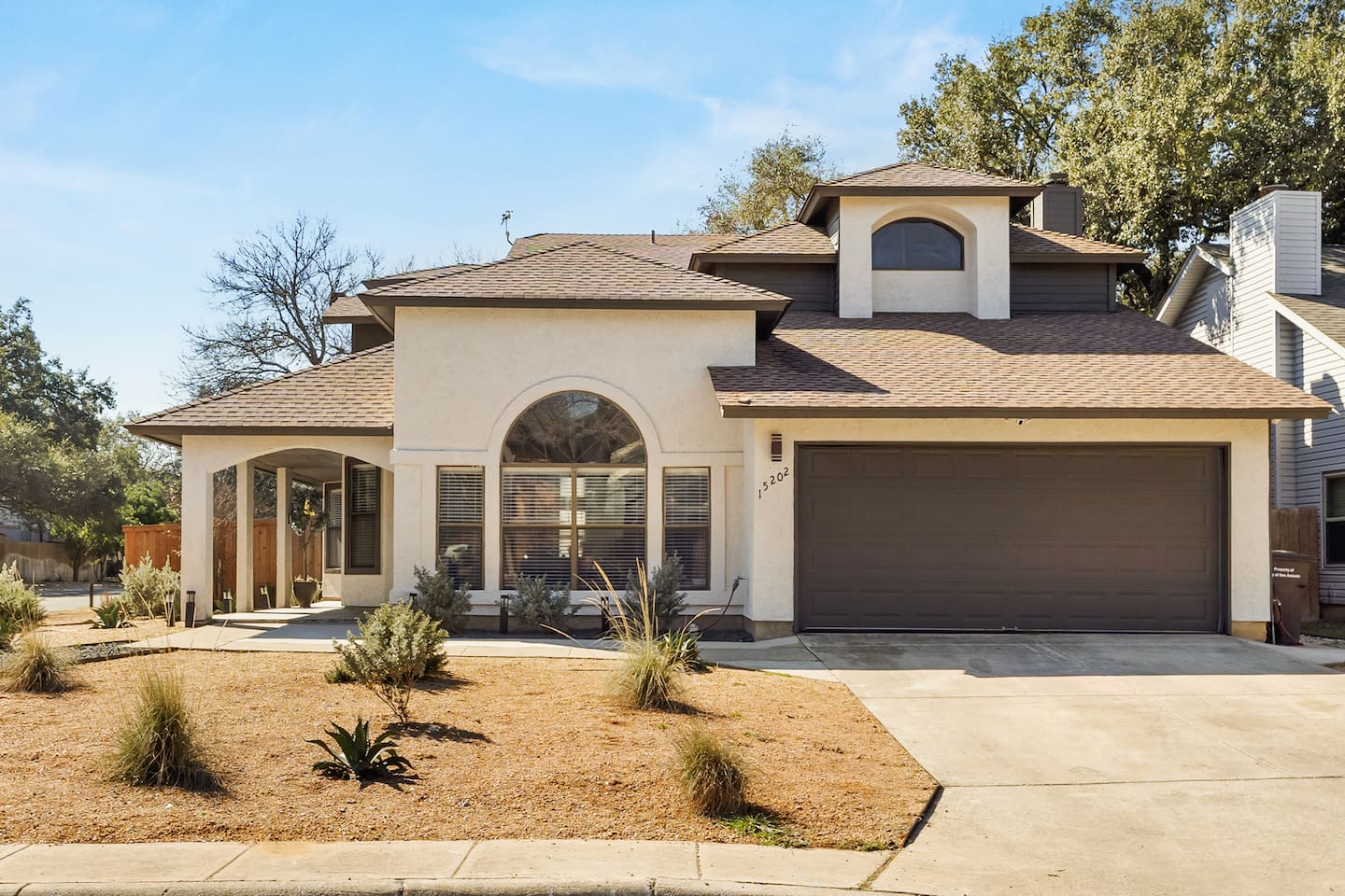 Beautiful curb appeal with a spacious driveway, arched front windows, and a welcoming modern exterior surrounded by mature trees. This charming home sets the tone for a relaxing, upscale stay—your perfect San Antonio getaway starts right here. 
