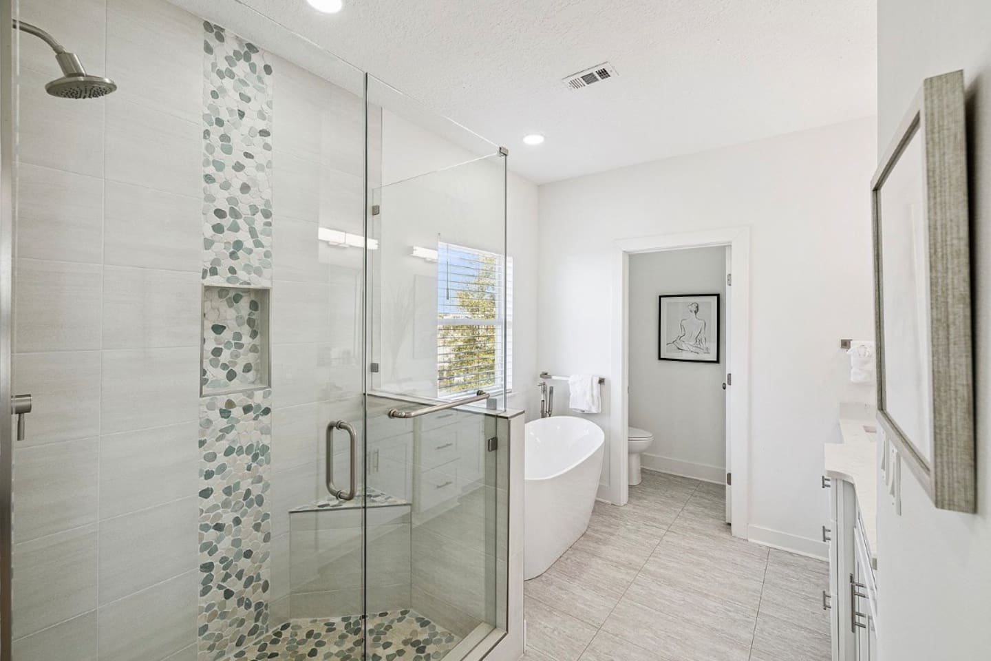 Sleek glass-enclosed walk-in shower featuring decorative stone accents for a true spa-like retreat