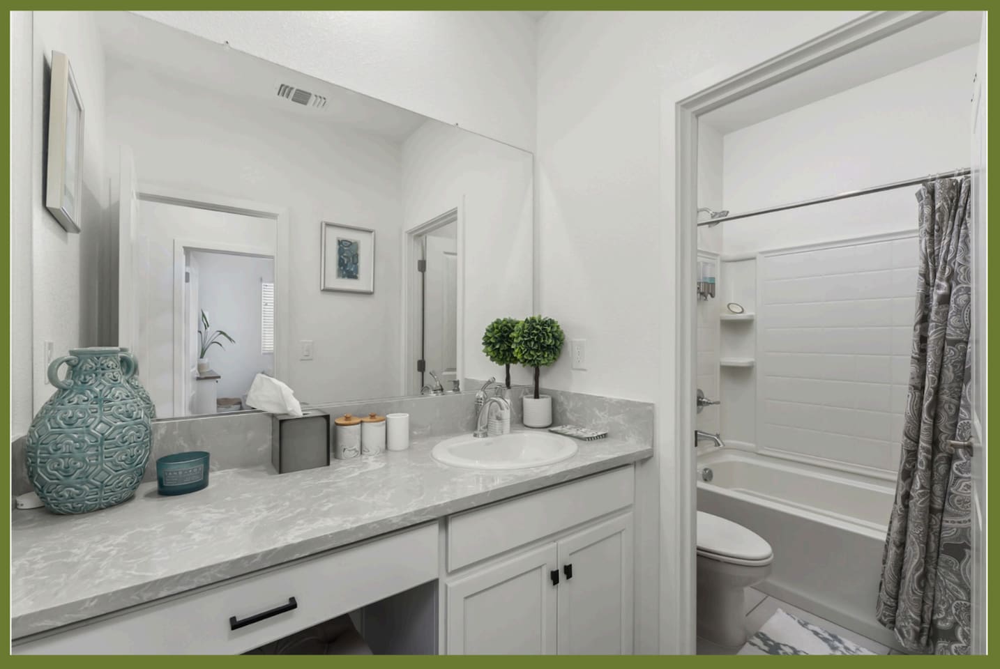 Bathroom vanity with counter space, storage cabinet, and easy access to the nearby shower/tub combination.