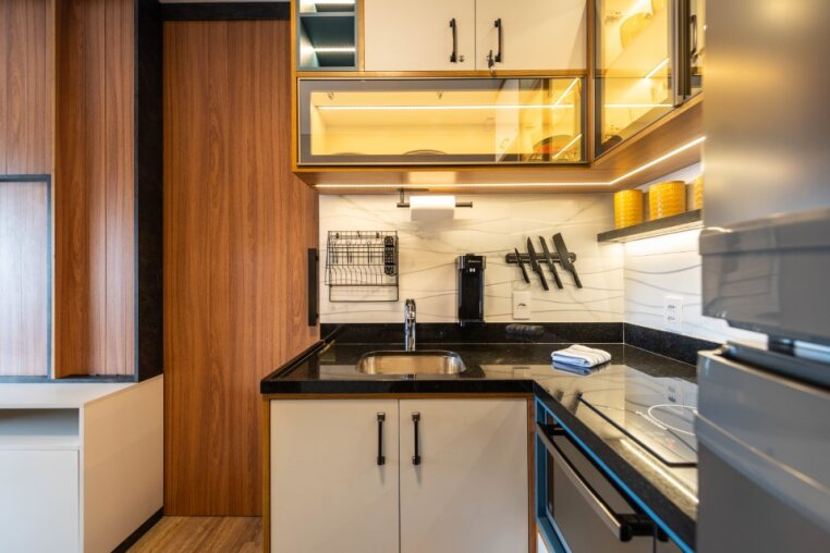 Bancada moderna com cuba em inox, cafeteira, suportes para utensílios e acabamento premium — conforto e estilo no coração de Pinheiros.