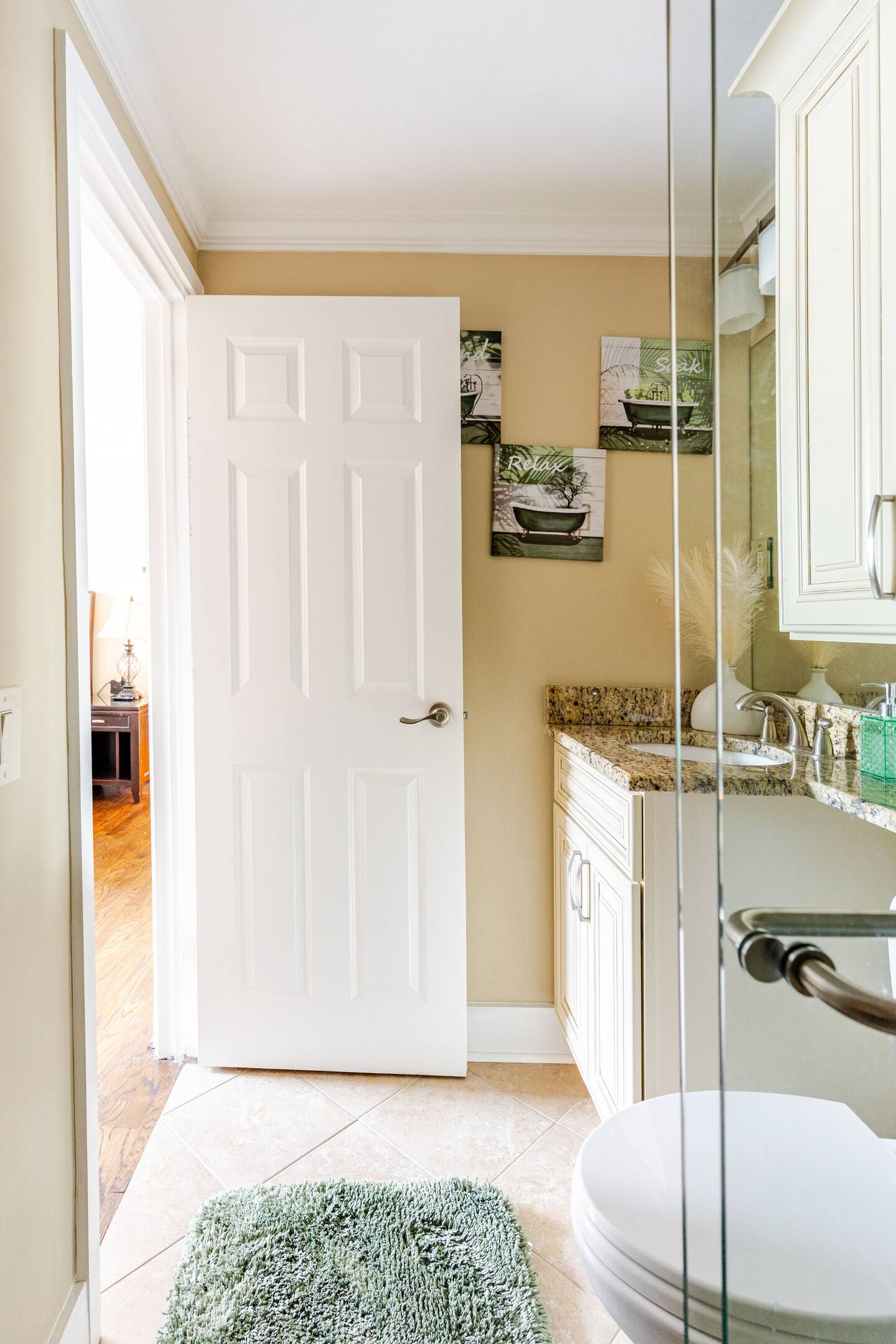 A beautifully appointed guest bathroom featuring a comfortable sitting chair for added convenience and comfort.