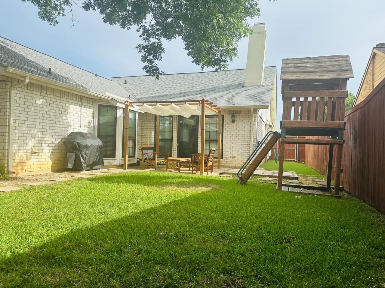 Backyard retreat with grill, seating, and space for entertaining.
