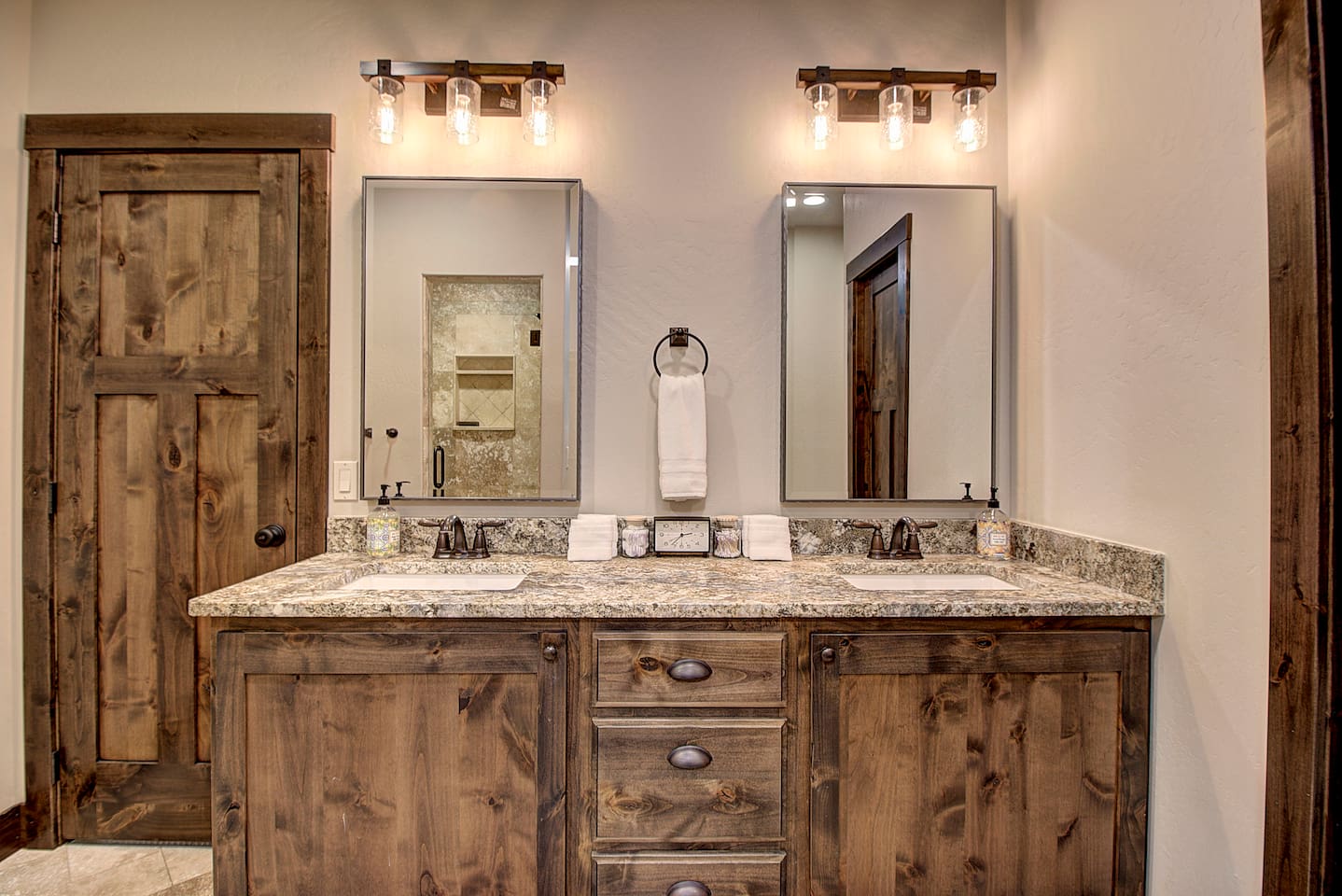 Master bathroom featuring a spacious double-sink vanity with rustic wood cabinetry.