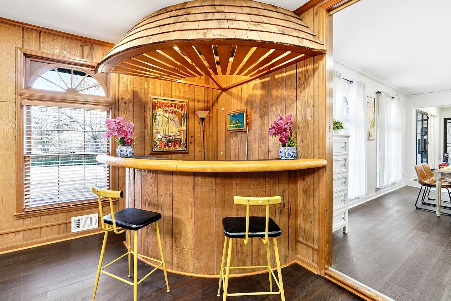 Enjoy this main-floor game room near the side entrance featuring a convertible pool and ping-pong table, a custom curved wood bar, and a Roku powered smart TV—ideal for entertaining and casual gatherings.